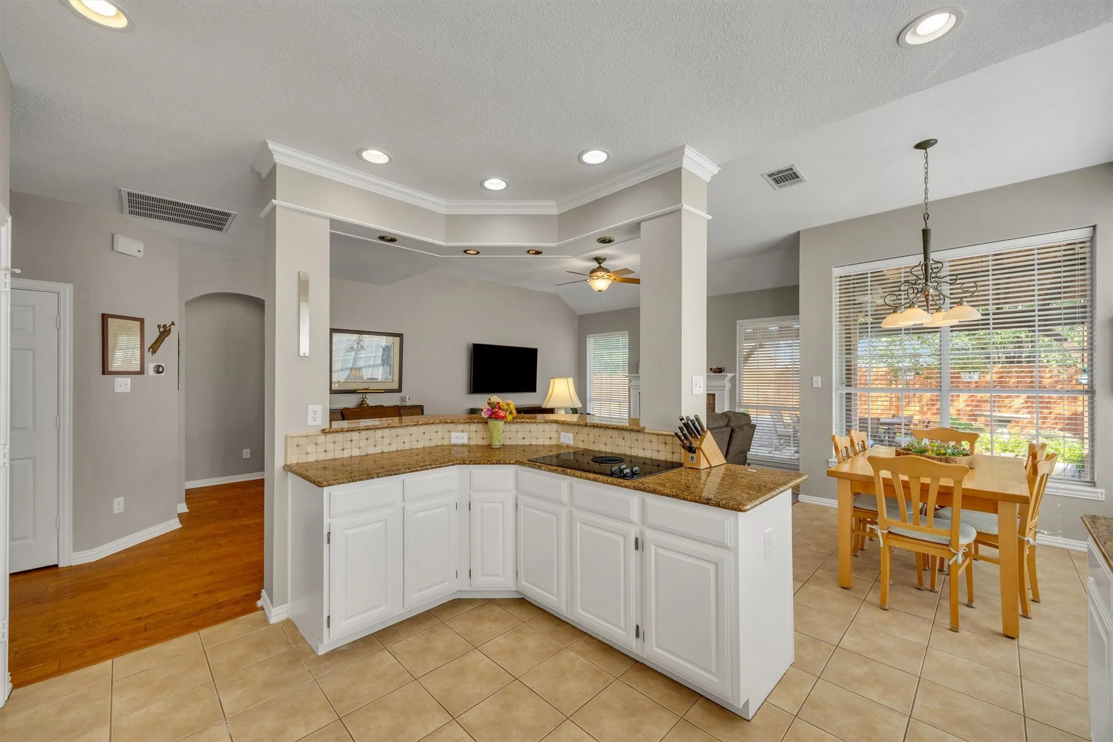 Door shown center left leads to the second pantry. Arched doorway next to that leads to primary suite. Electric cooktop with downdraft vent exits through the slab to the exterior.