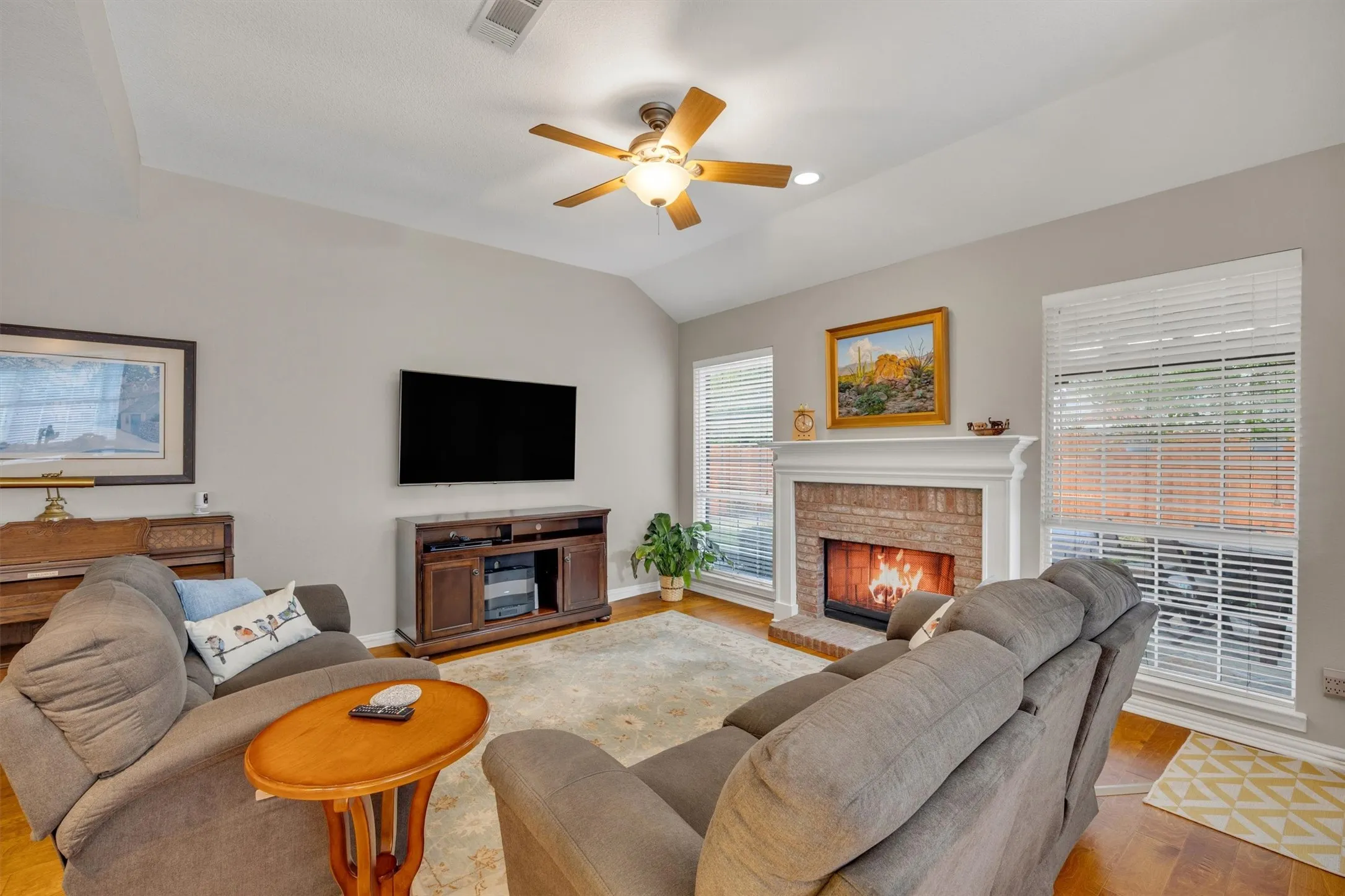 The den features tall ceilings, a gas fireplace and views to the back yard.