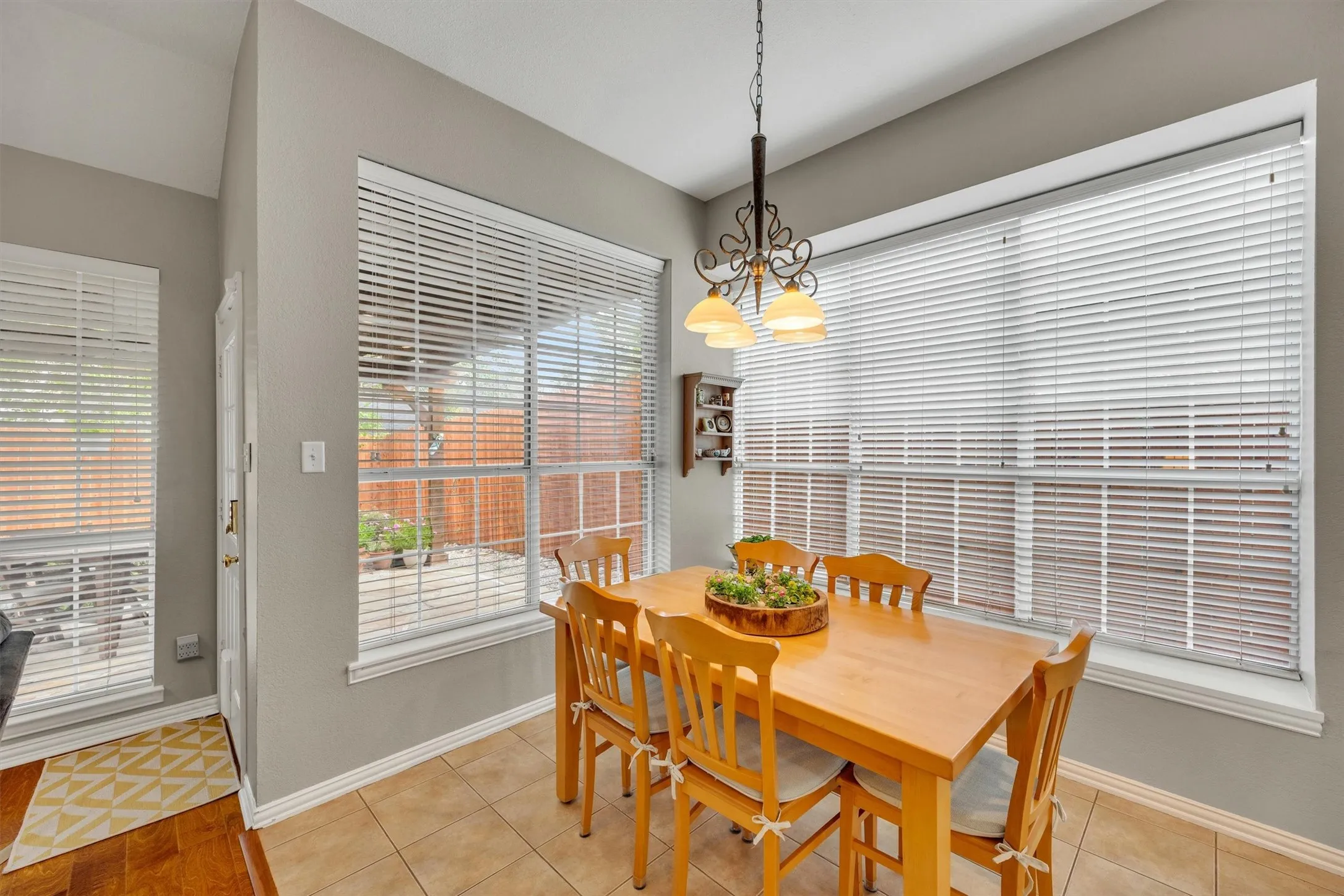 Tile flooring, large windows with blinds, recessed lighting, and a decorative light fixture