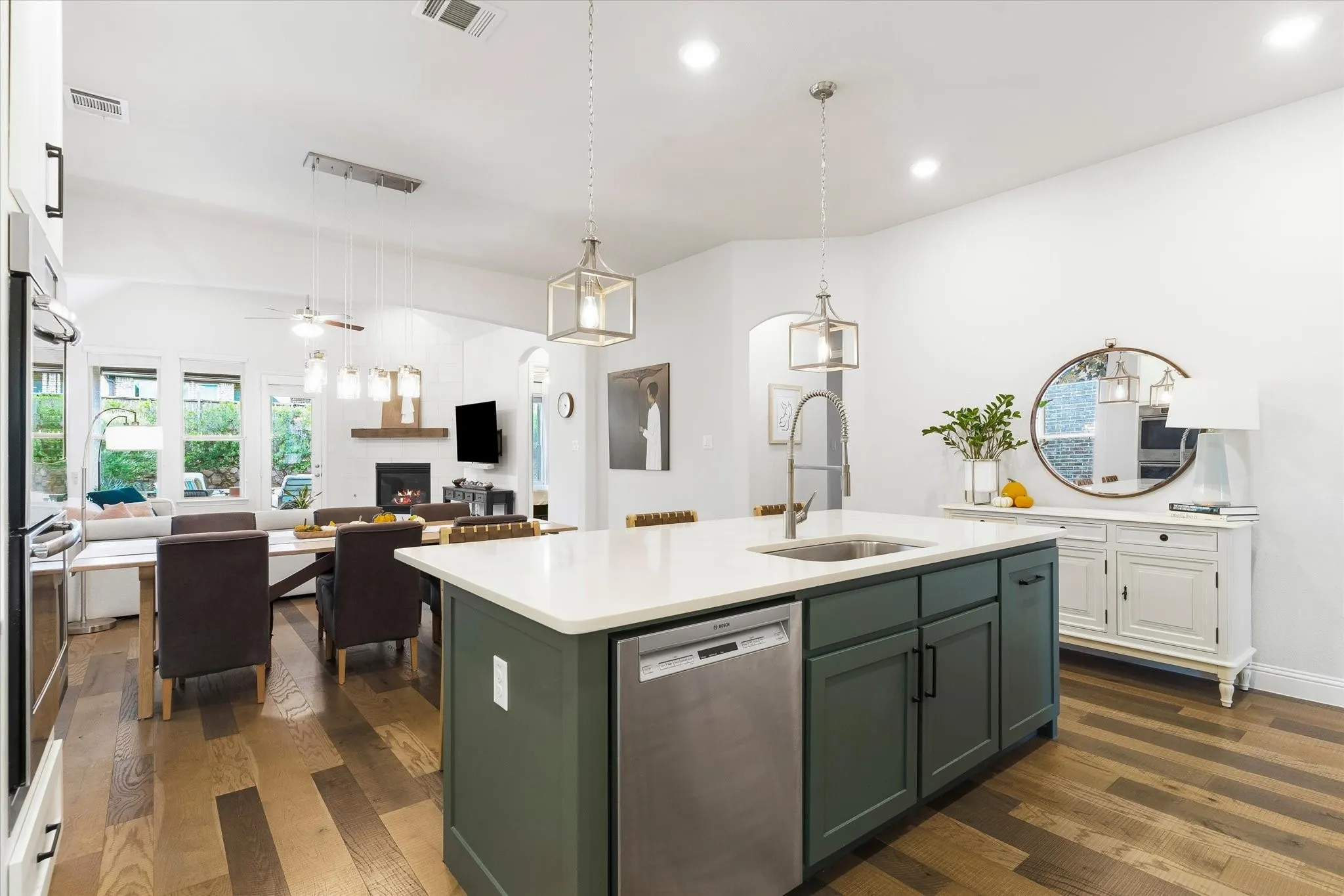 Kitchen island with a stainless steel sink, a stainless steel dishwasher, and a white countertop