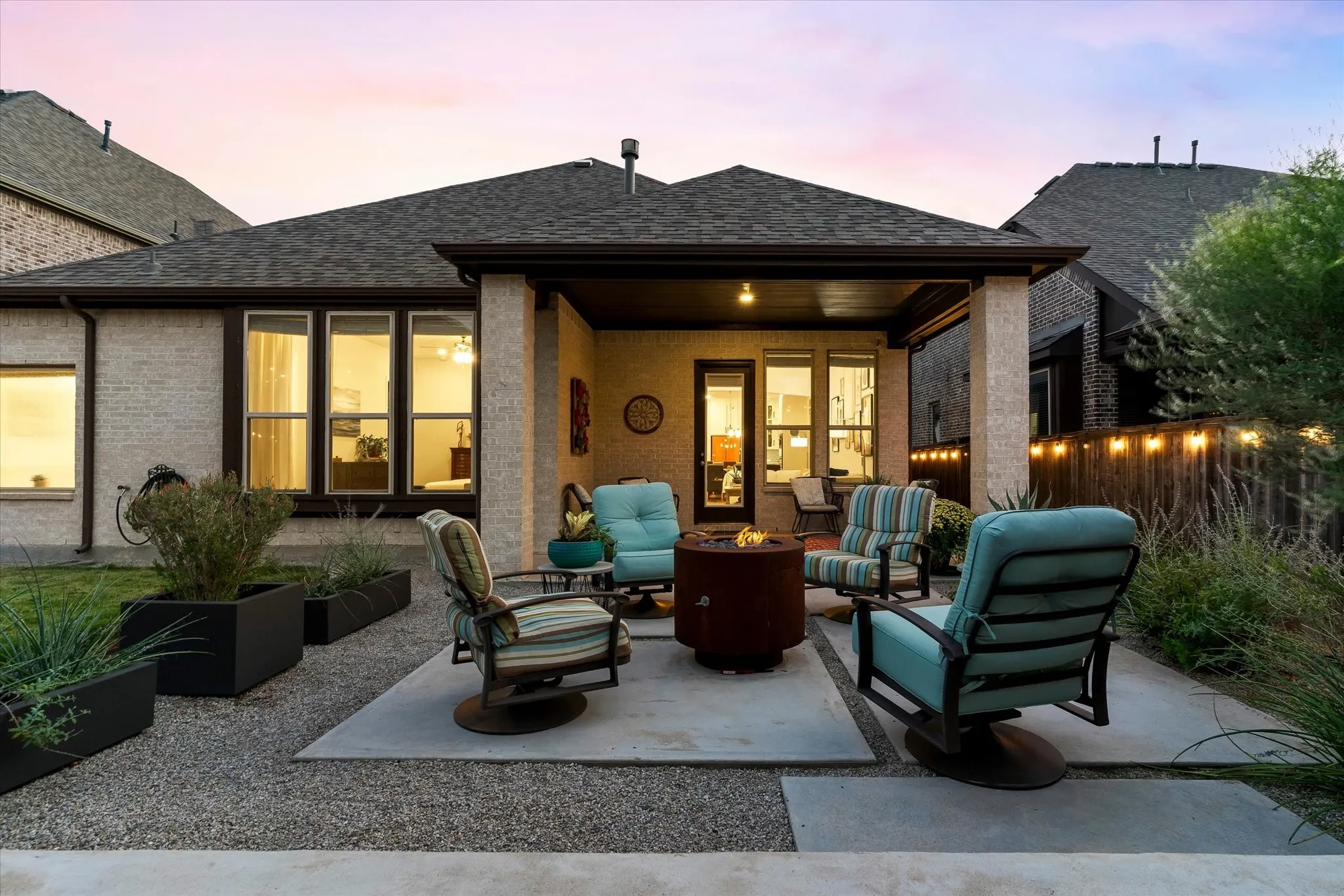 Covered outdoor patio featuring a concrete surface, gravel hardscaping, and a fully fenced perimeter