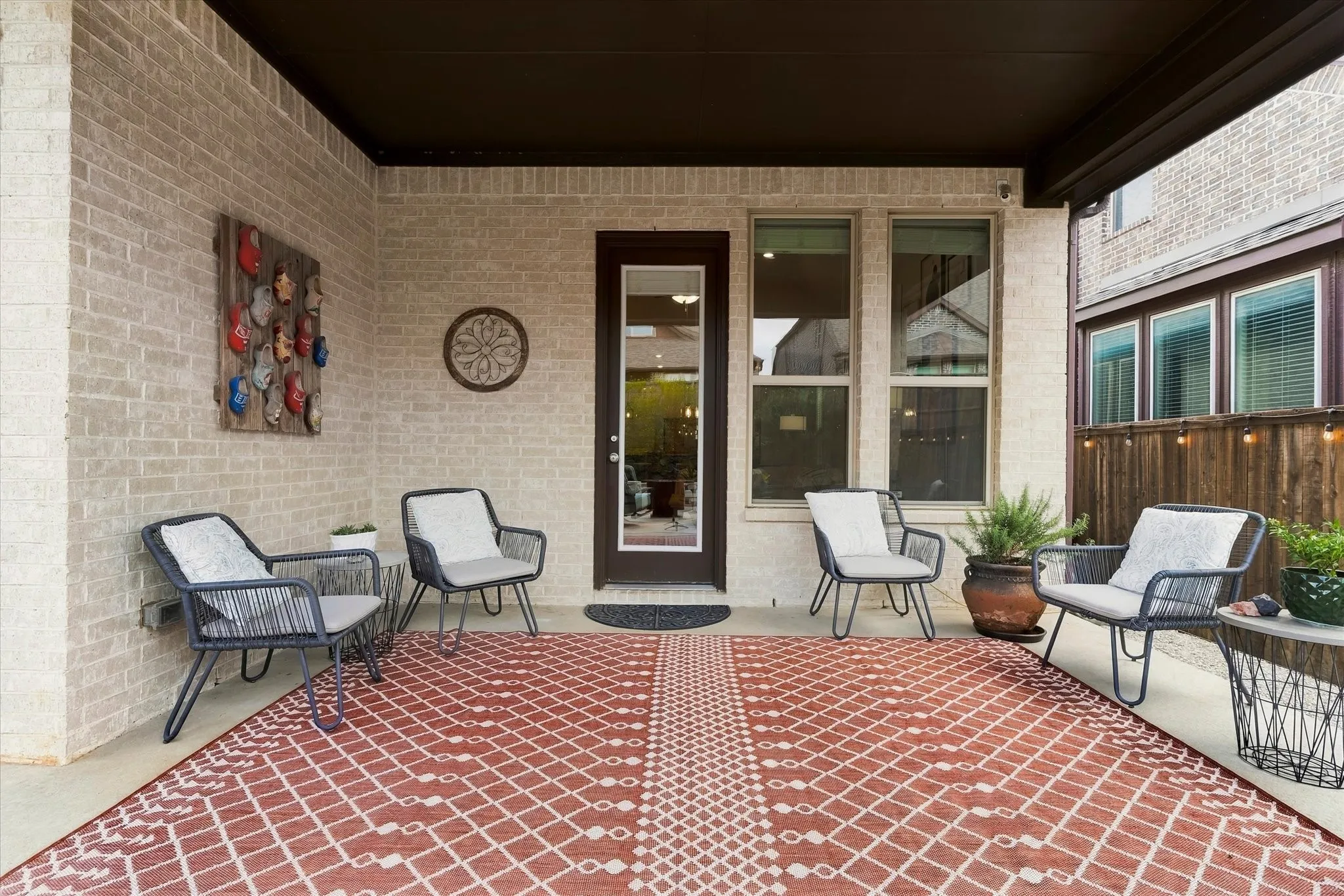 Covered patio featuring a brick exterior, recessed lighting, and a glass-paneled door