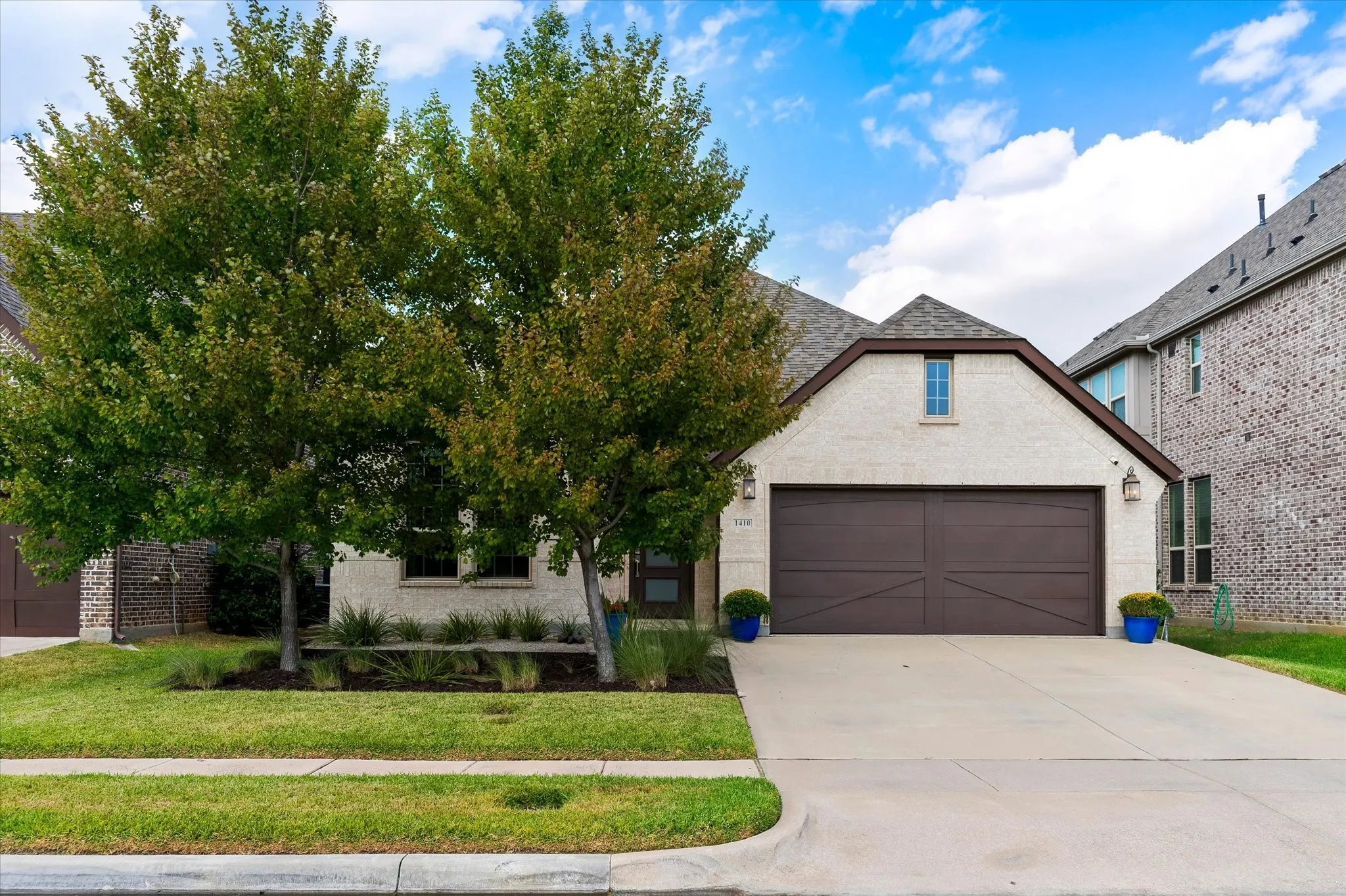 Cream-colored brick exterior with a brown garage door