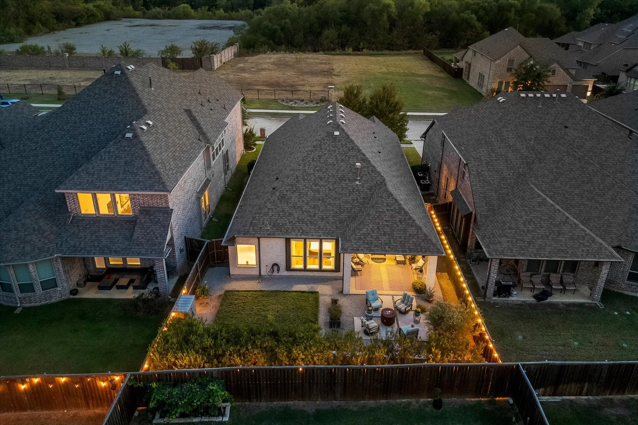Expansive backyard featuring a covered patio, paved outdoor living space, and manicured lawn