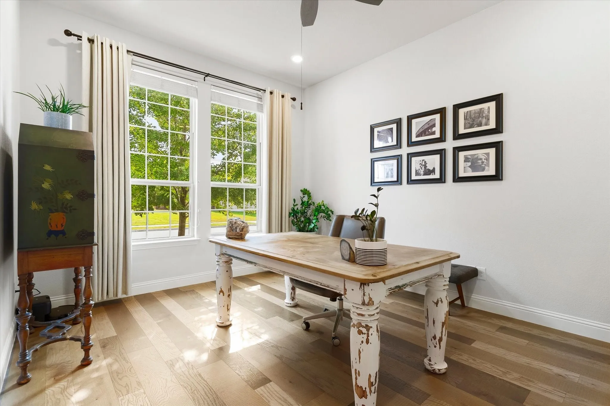 Light-toned wood-finish flooring complements white walls and large windows
