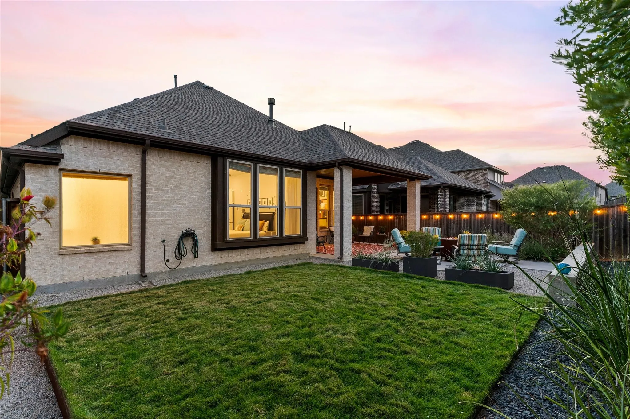 Expansive backyard with a manicured lawn, dedicated patio space, and a covered outdoor living area