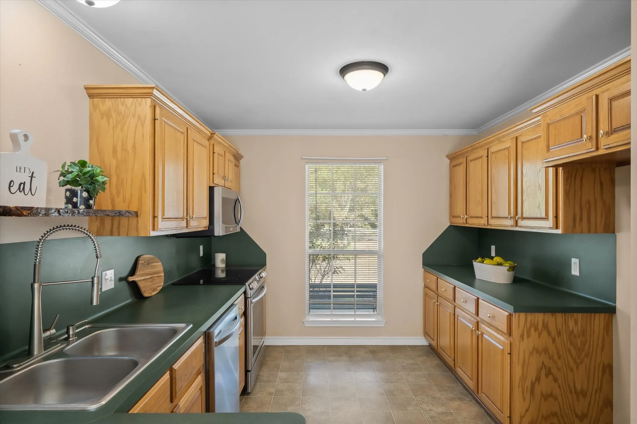 Oak cabinetry and a trendy color green counters makes this a perfect homestead farmhouse