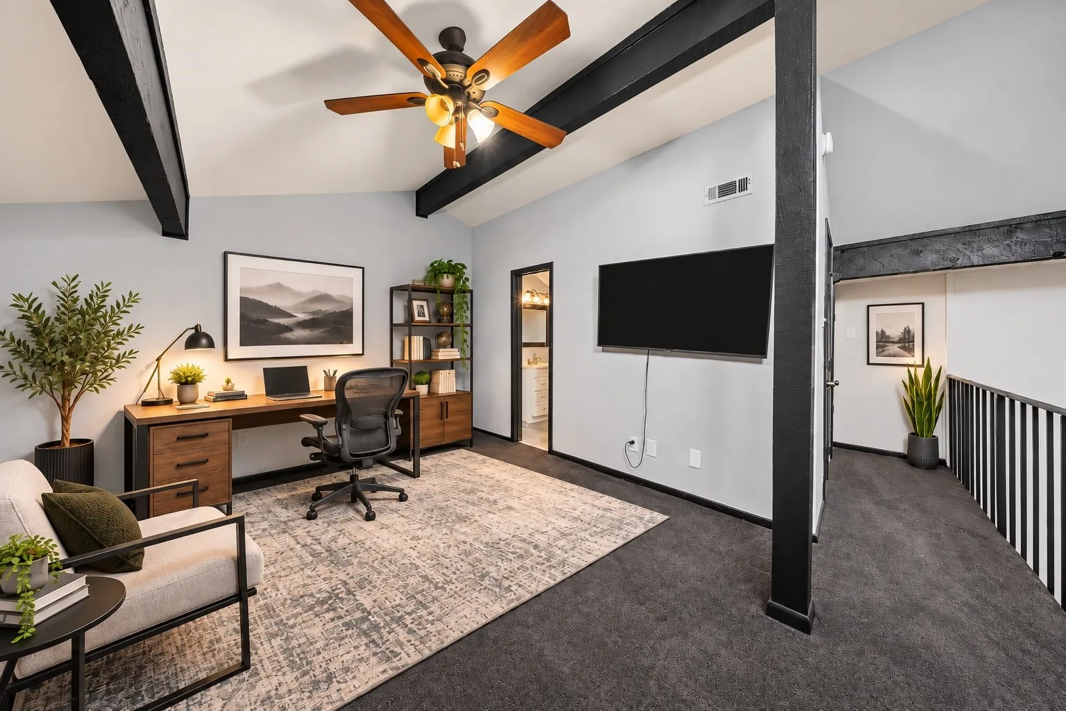 Vaulted ceiling with exposed beams, wood-finish ceiling fan, and dark-finish railing