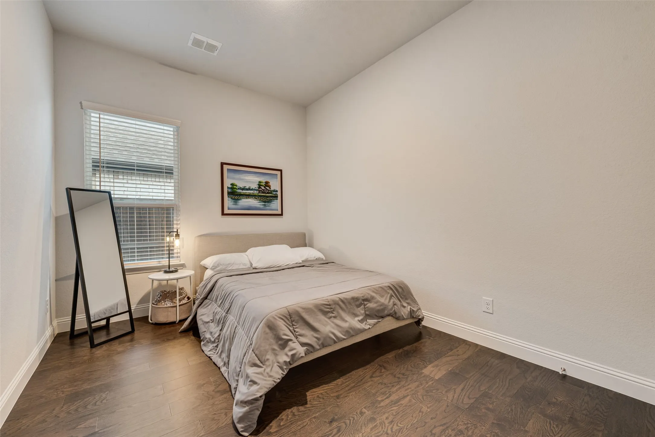 Vaulted ceiling with a white finish, single window with blinds, dark wood-finish flooring, and white walls