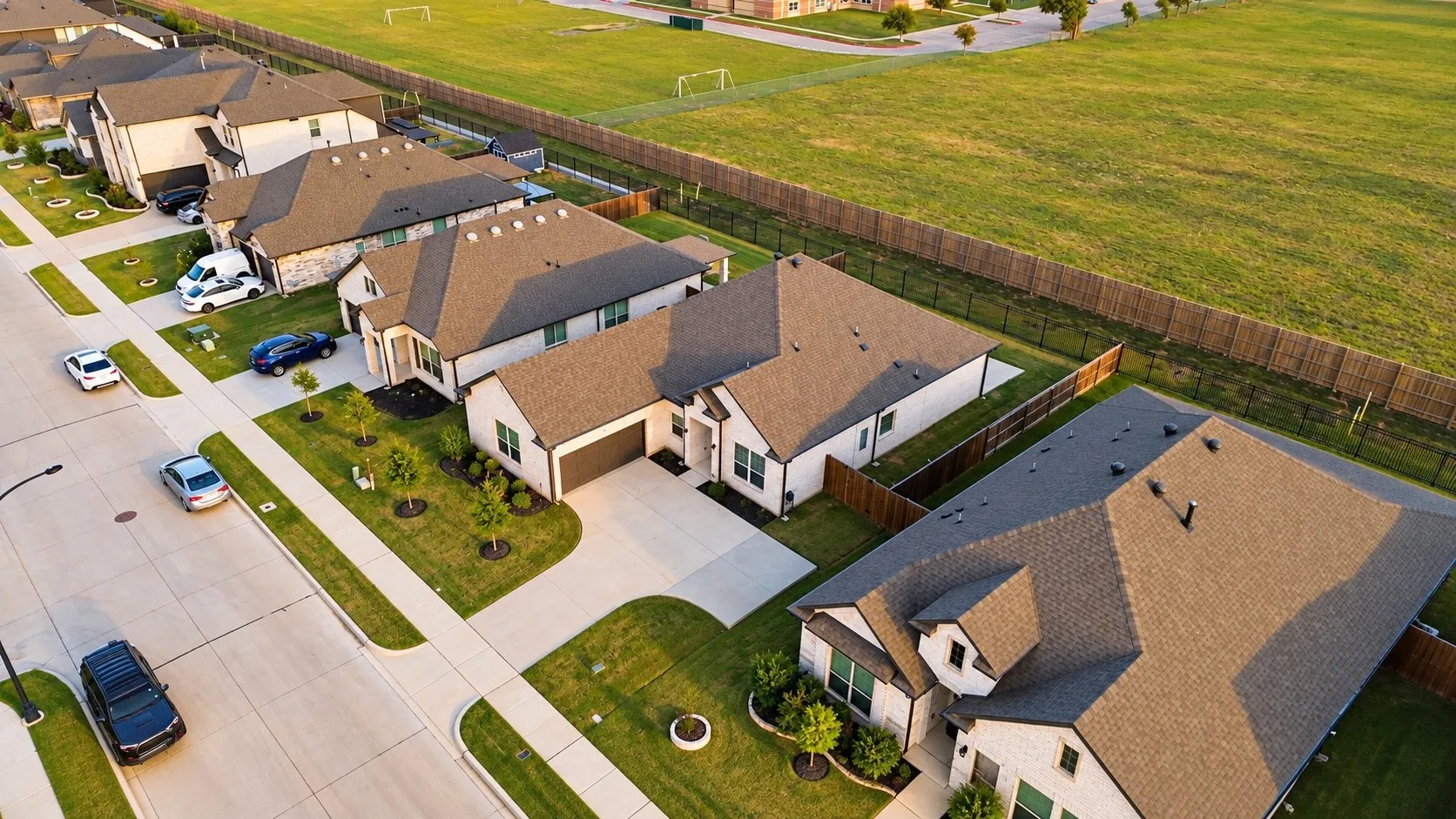 Contemporary residential architecture with a detached garage, concrete driveways, and manicured landscaping