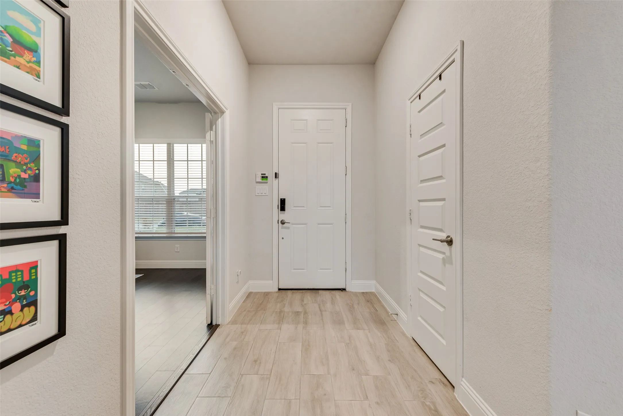 Entryway featuring wood-finish flooring, white paneled doors, and light-toned walls