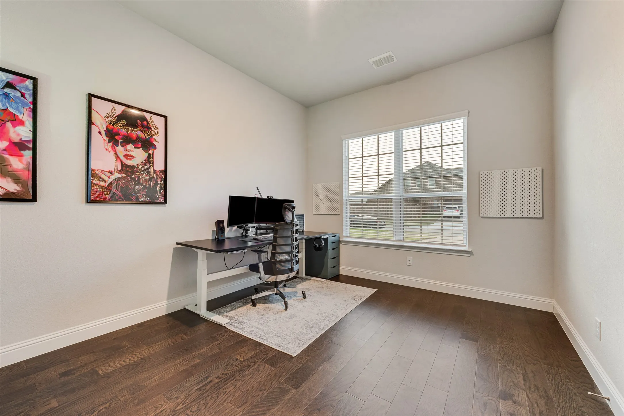 Spacious Office featuring wood-finish flooring, a large window with blinds, and white trim