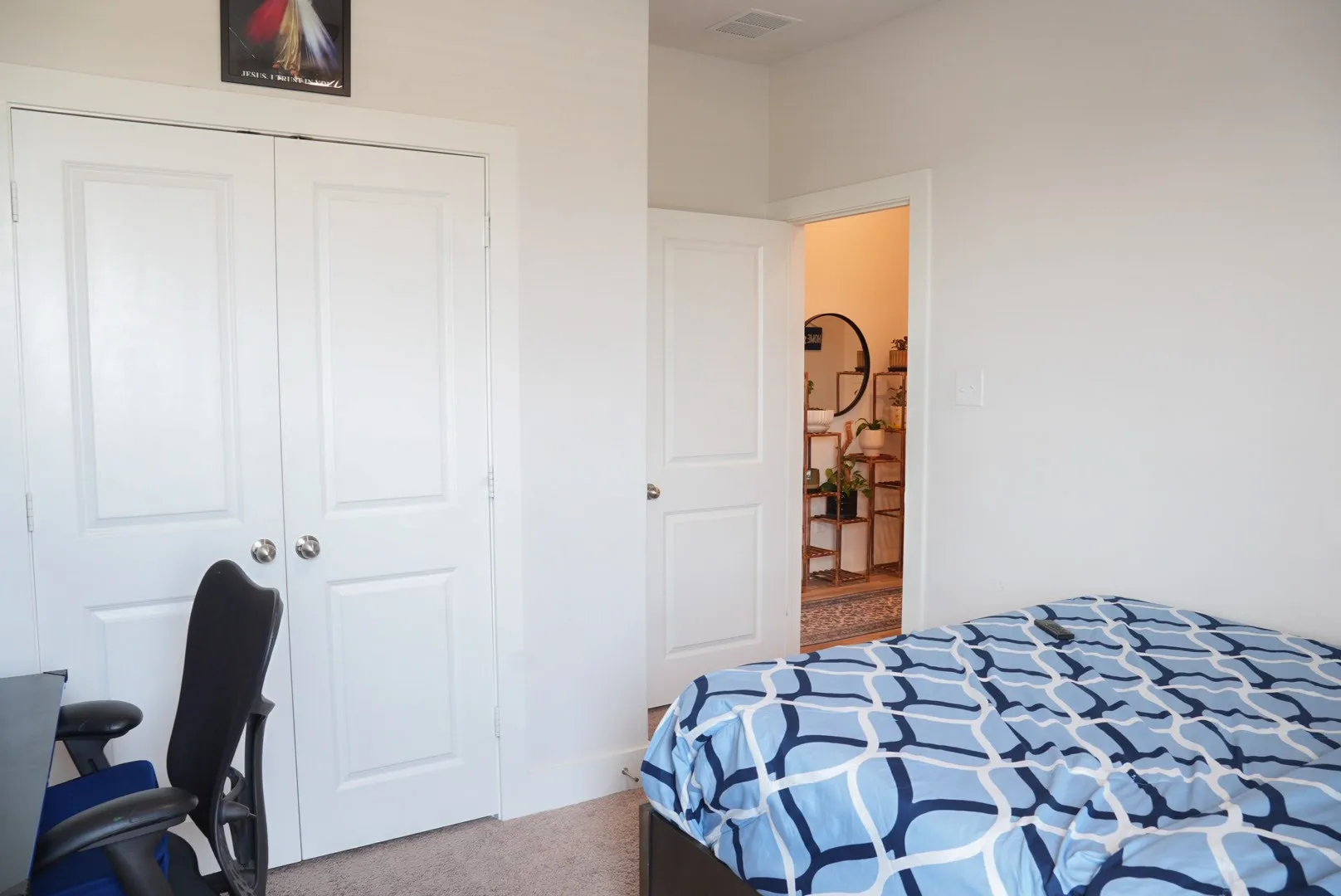 White paneled closet doors, neutral wall paint, and light-toned carpeting