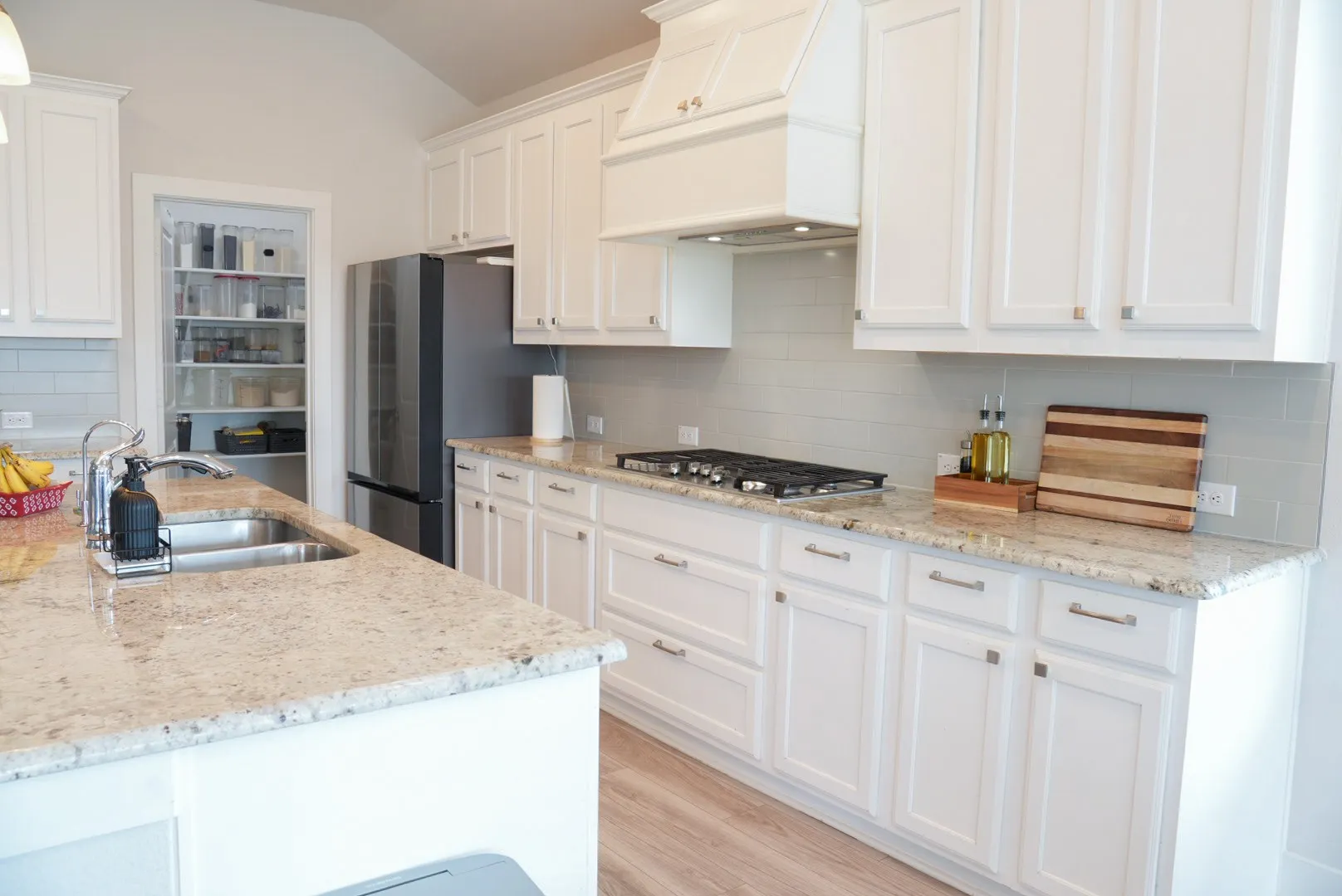 Kitchen featuring white cabinetry, granite countertops, stainless steel appliances, a gas range, and a subway tile backsplash