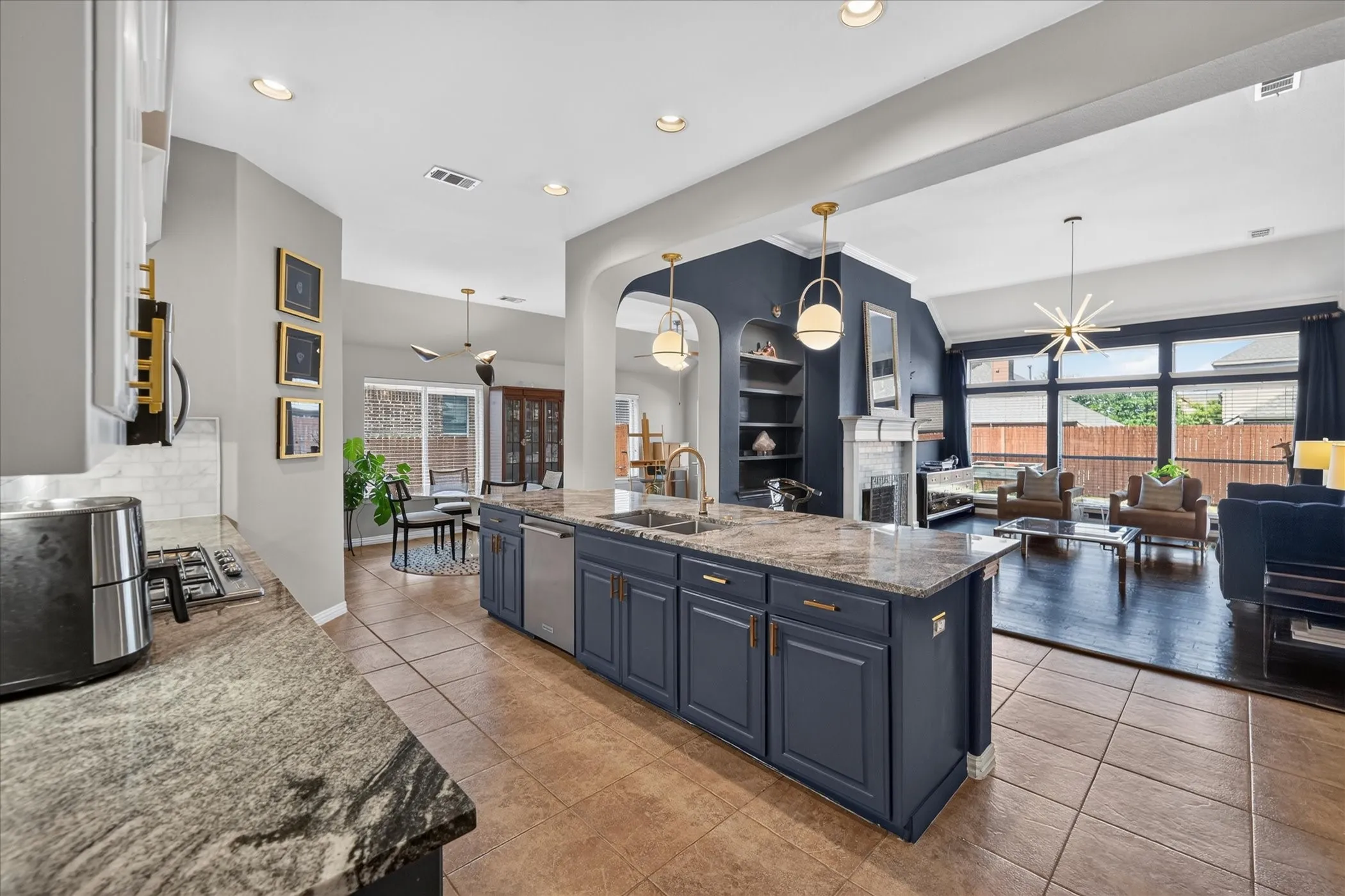 Kitchen island featuring a dual basin sink, stainless steel dishwasher, and gold-finish hardware