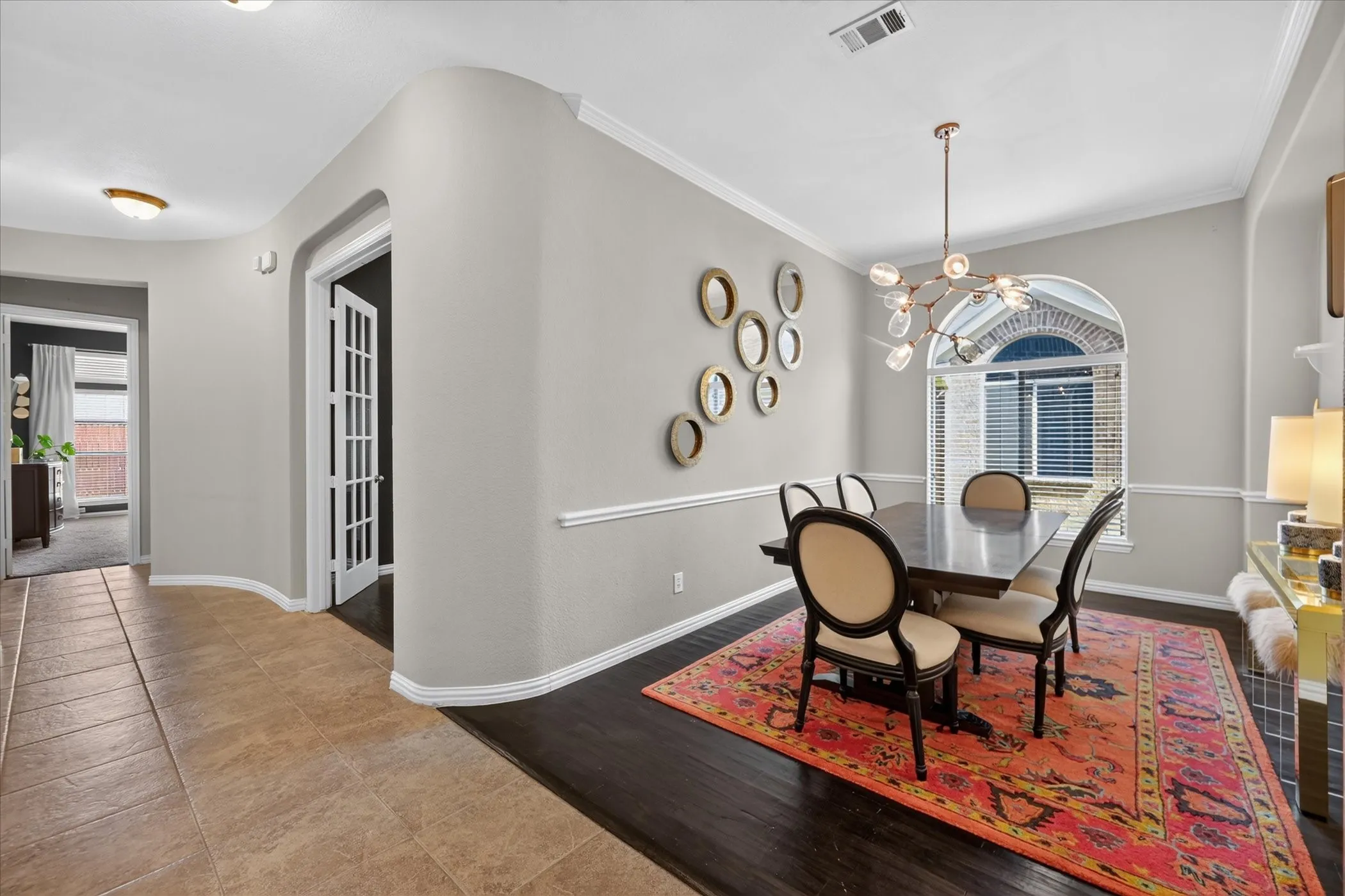 Recessed lighting illuminates the tiled entry, opening to a space with wood-finish flooring