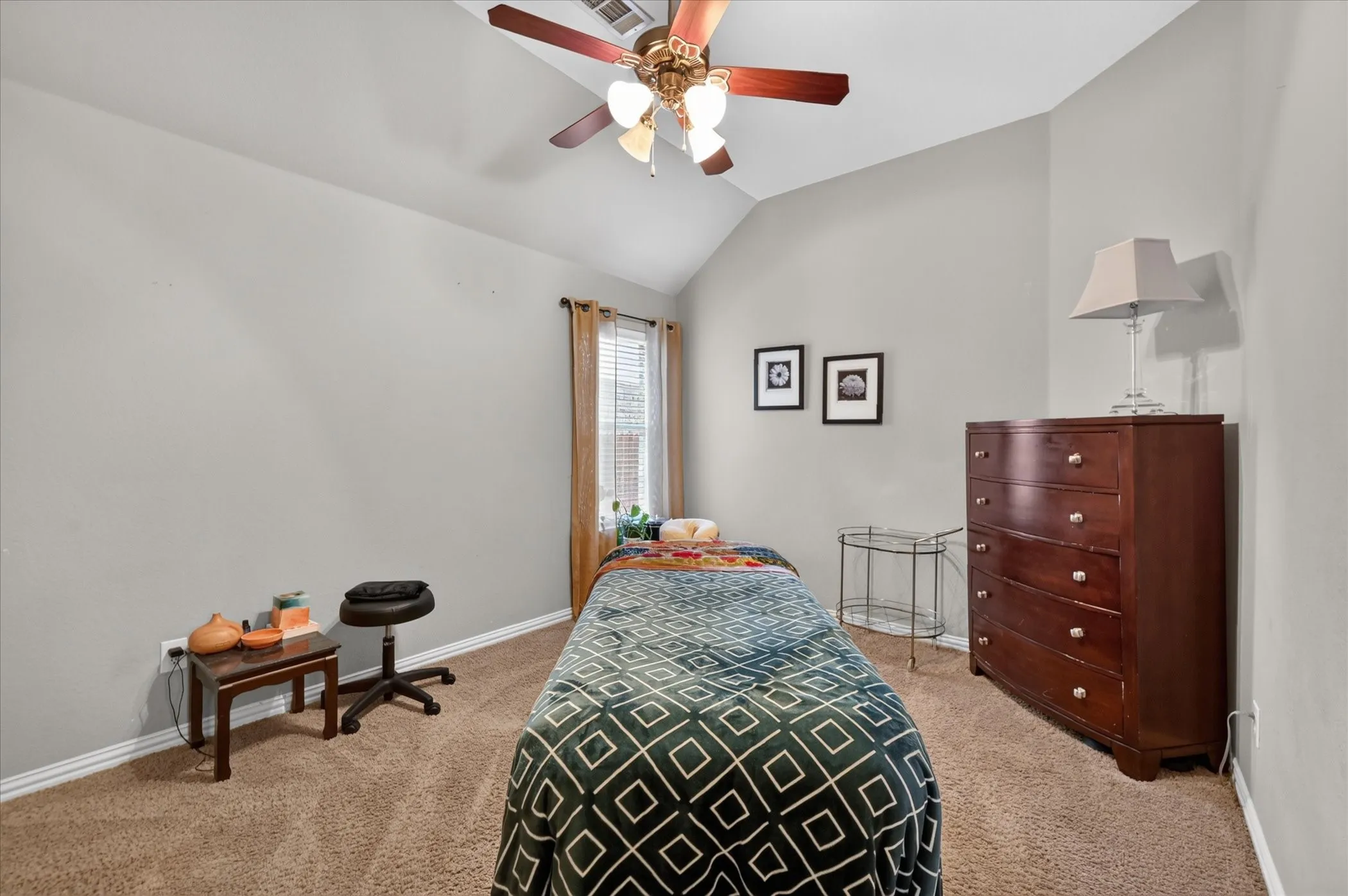 Vaulted ceiling with an attached ceiling fan, neutral wall paint, and carpet flooring
