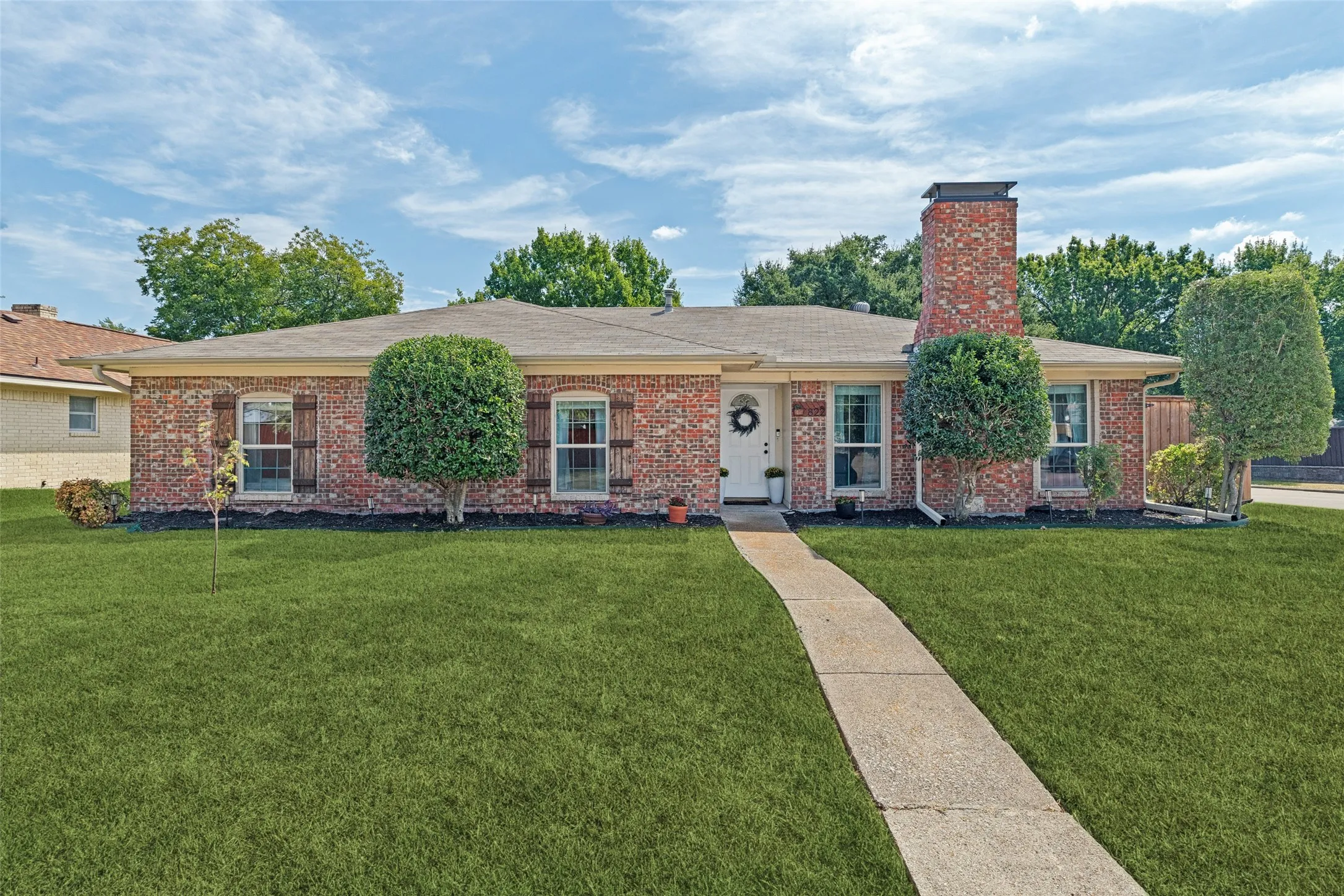 Brick exterior, freshly landscaped.  Grass has been digitally enhanced.