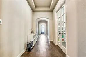 Hallway featuring wood-finish flooring, a coffered ceiling, and a French door entry