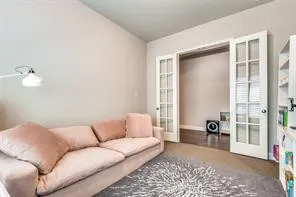 Vaulted ceiling, neutral wall tones, French doors, and wood-finish flooring