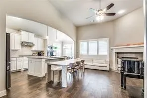Arched entryway leads to a kitchen featuring white cabinetry and a center island