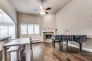 Vaulted ceilings with a ceiling fan, recessed lighting, wood-finish flooring, a fireplace with a mantel, and window blinds