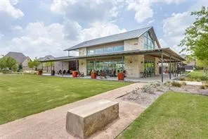 Stone-clad building with a pitched roof and expansive glass frontage