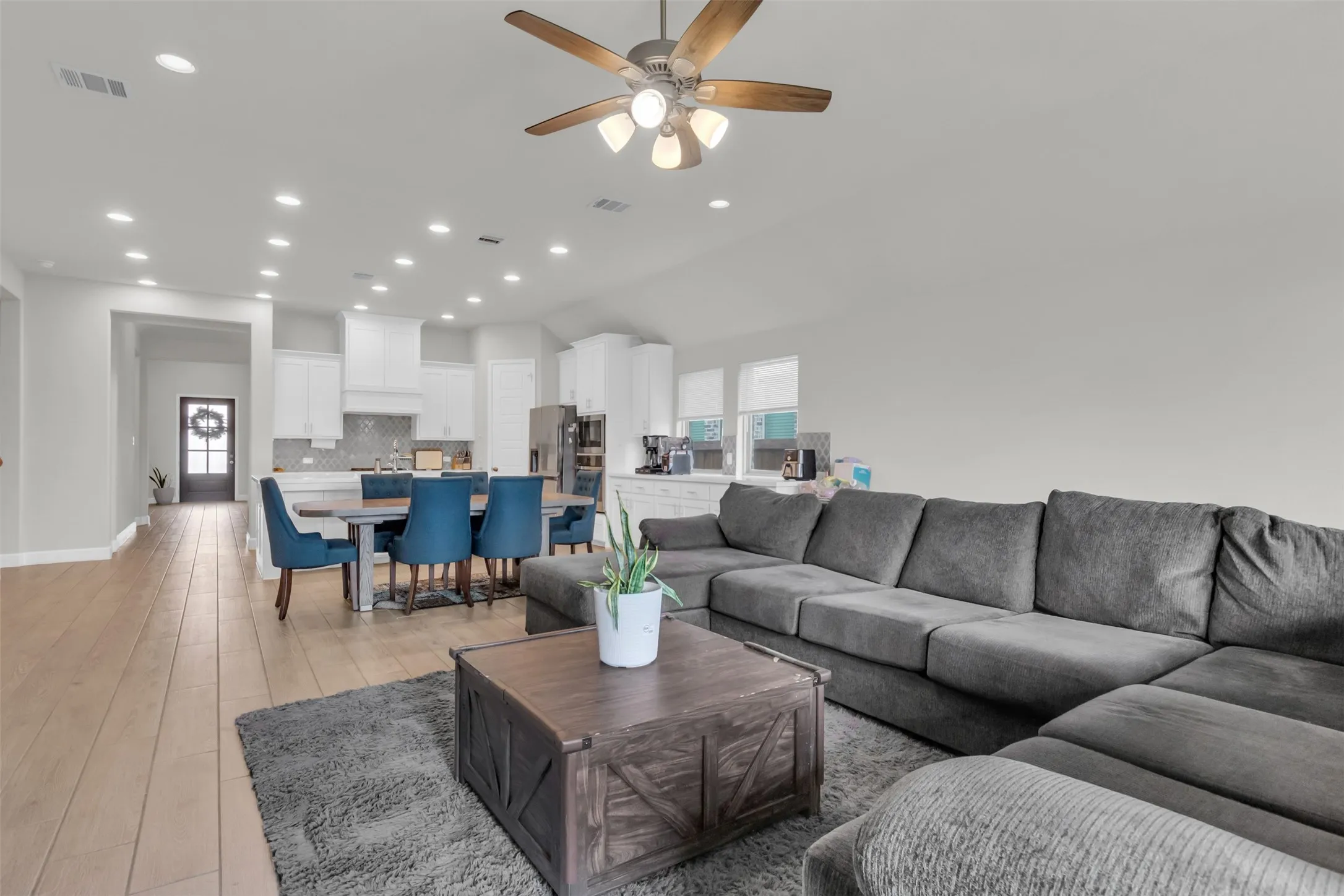 Living room featuring healthy amount of natural light, light wood finished floors, recessed lighting, lofted ceiling, and ceiling fan