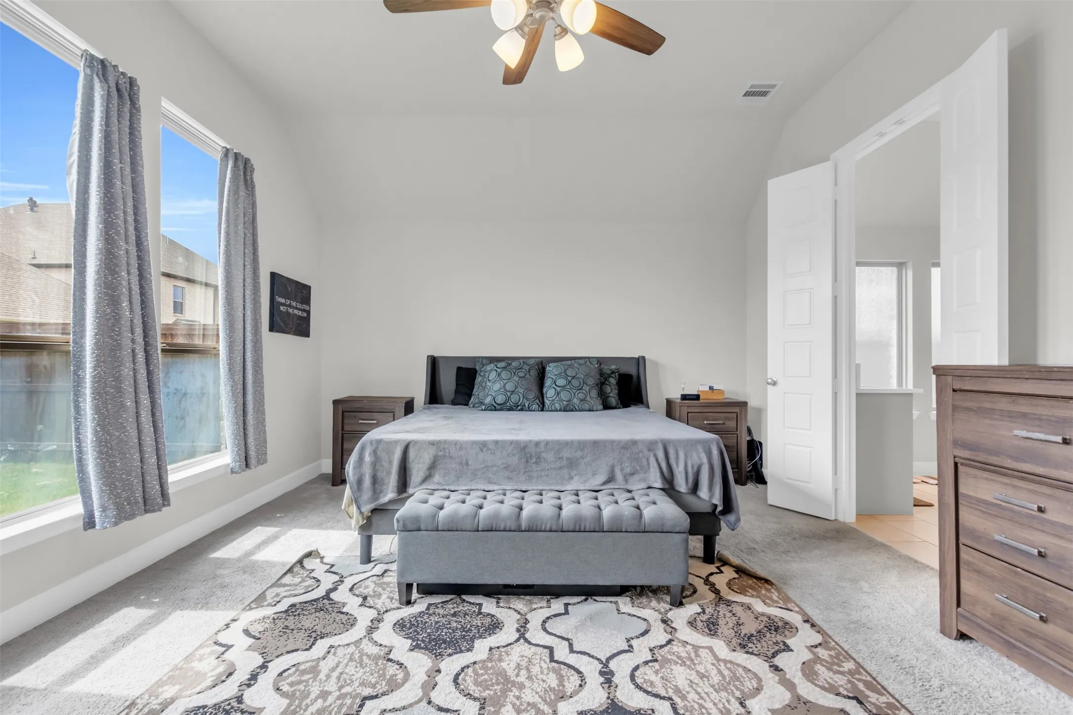 Bedroom featuring carpet, vaulted ceiling, and a ceiling fan