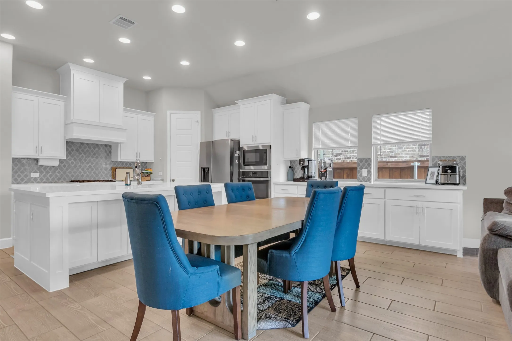 Dining area with light wood-style floors and recessed lighting