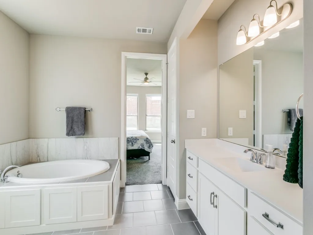 Primary bath features separate vanities recently upgraded to granite and soaking tub