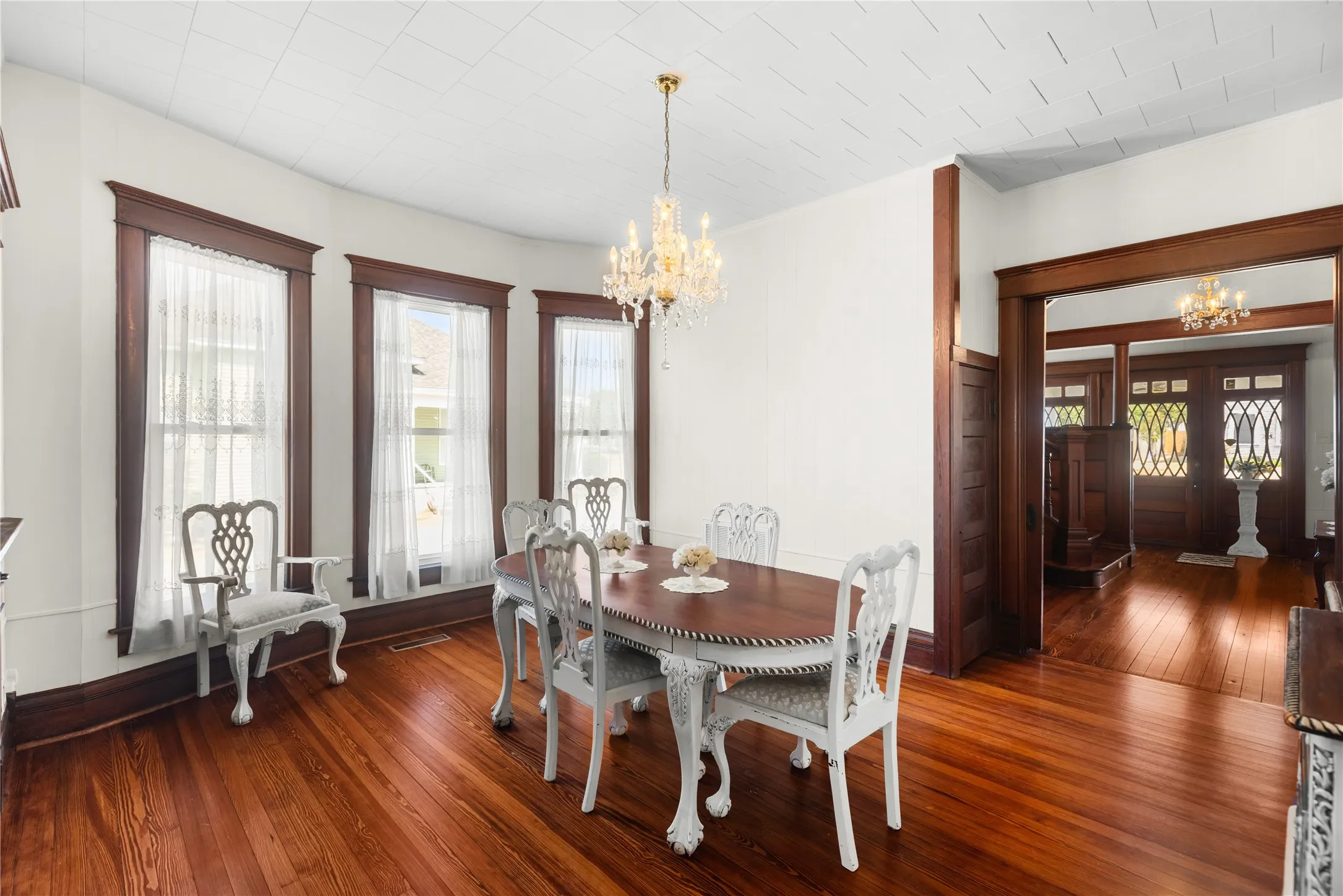 Hardwood flooring throughout, a decorative chandelier, and extensive wood trim