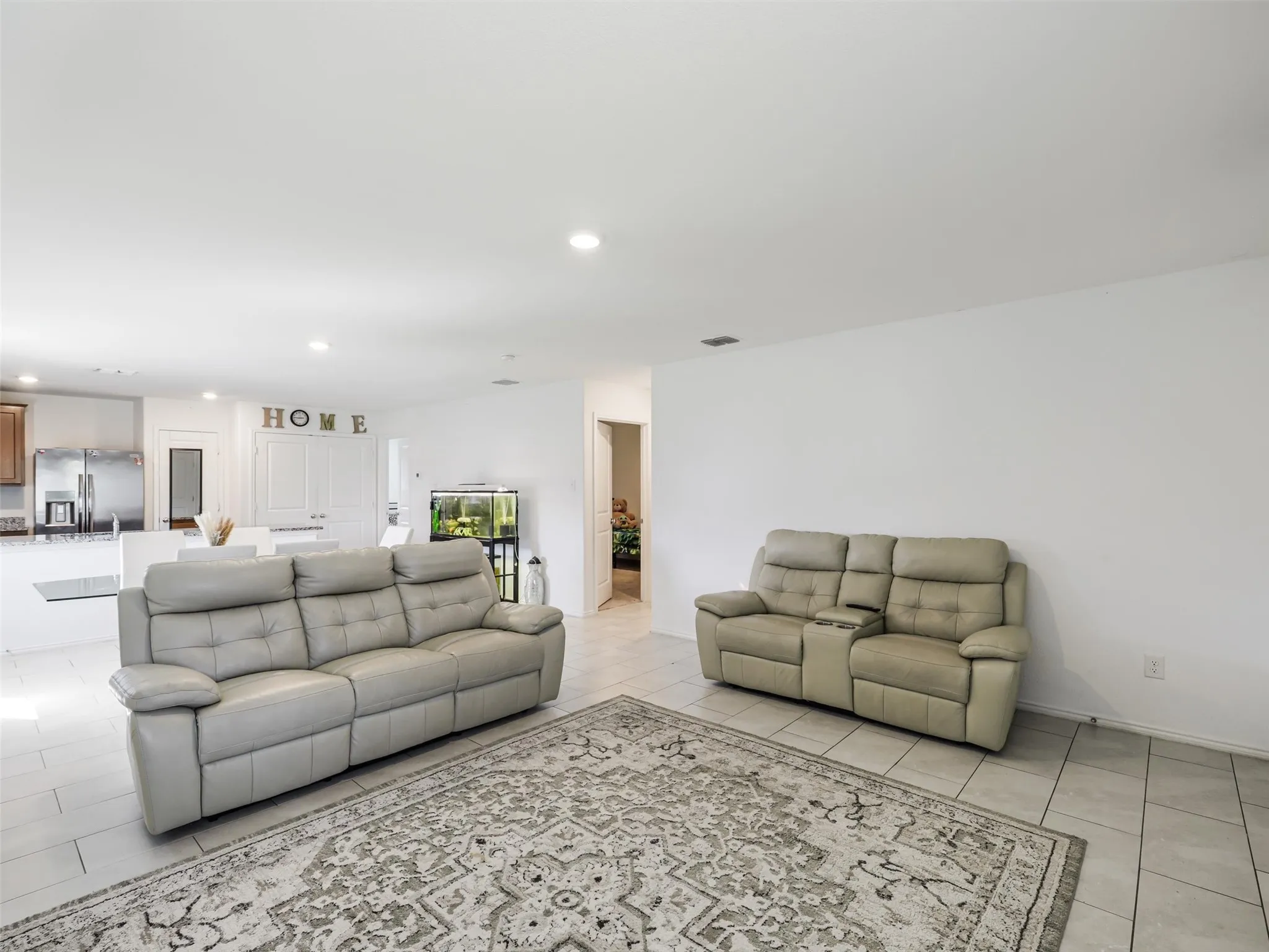 Recessed lighting, tile flooring, and white walls
