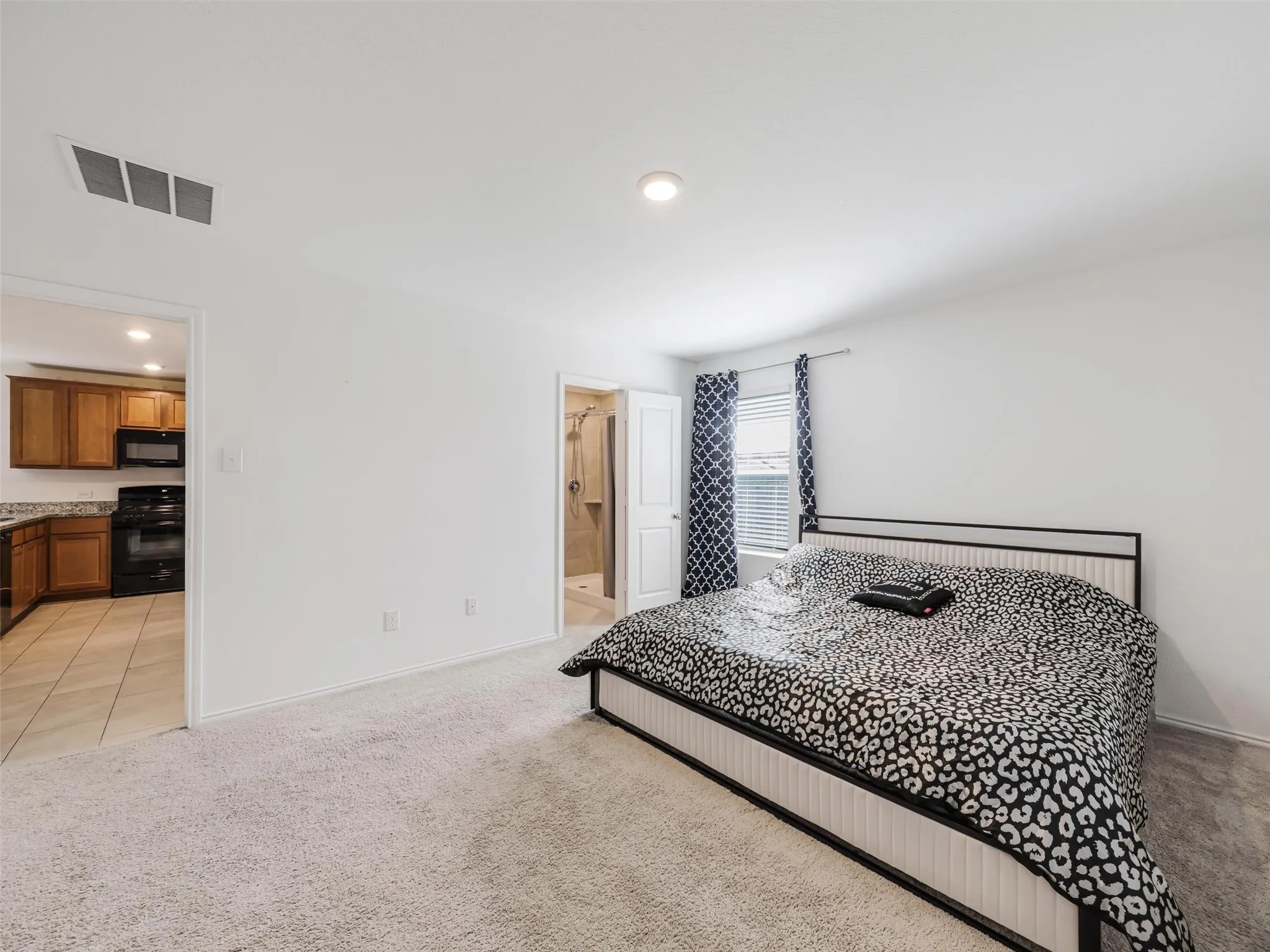 Carpeted bedroom with a single window, recessed lighting, and white walls