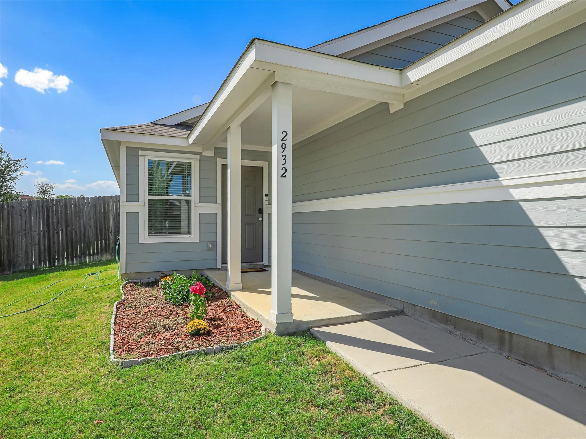 Light blue horizontal siding and a covered front entry