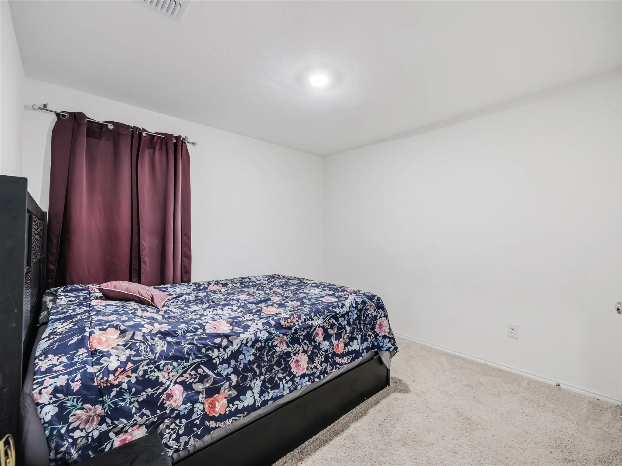 Recessed ceiling lighting, white painted walls, and light-colored carpeting