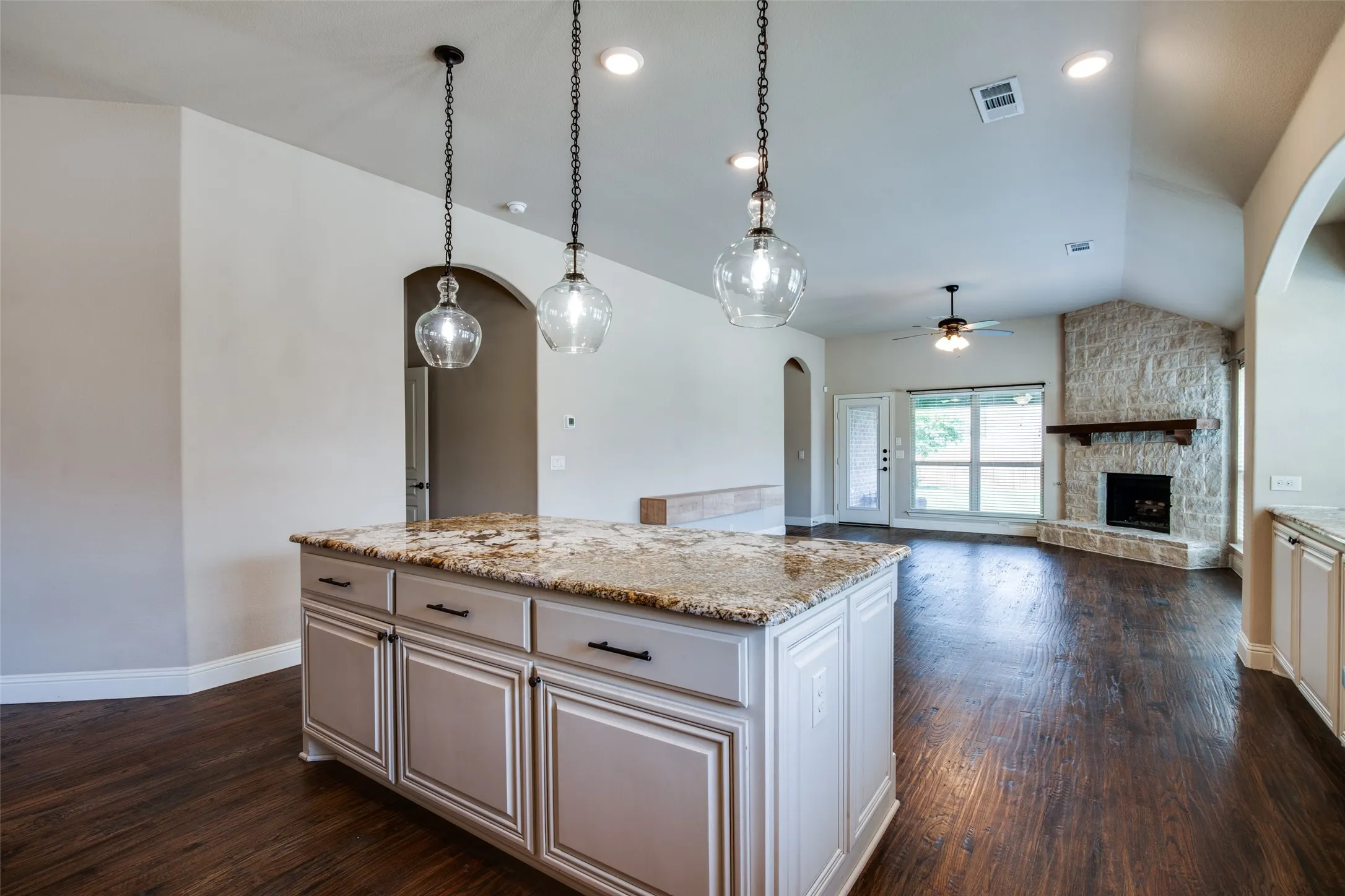 Kitchen island with granite countertop and pendant lighting