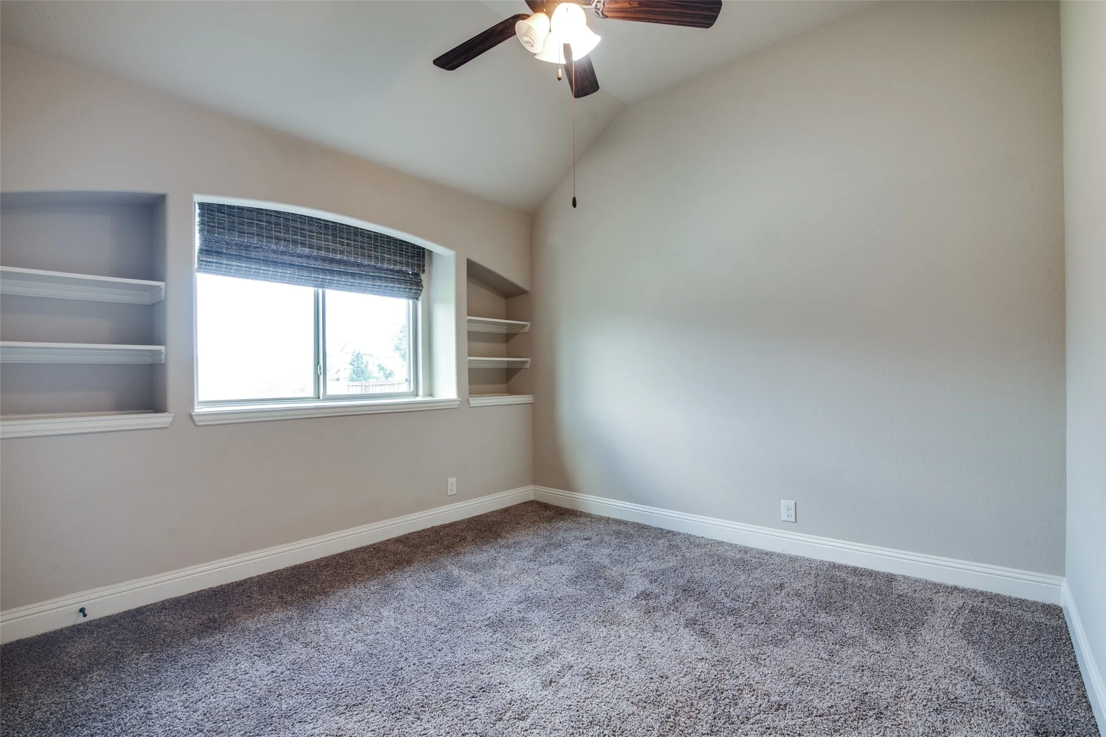 Vaulted ceiling, built-in shelving, window with blind, ceiling fan with light, and carpeted flooring