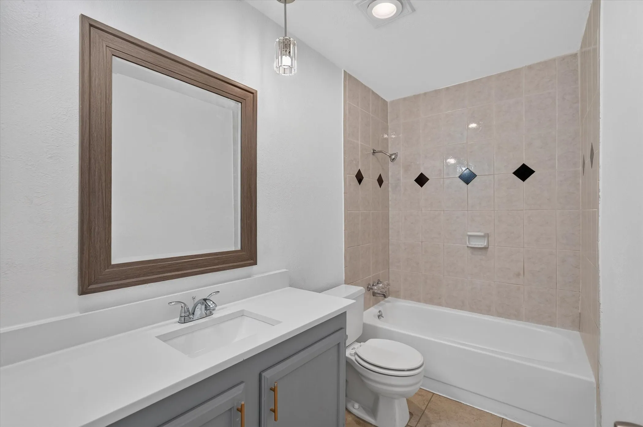 Updated bathroom featuring vanity with quartz countertop and gray cabinetry