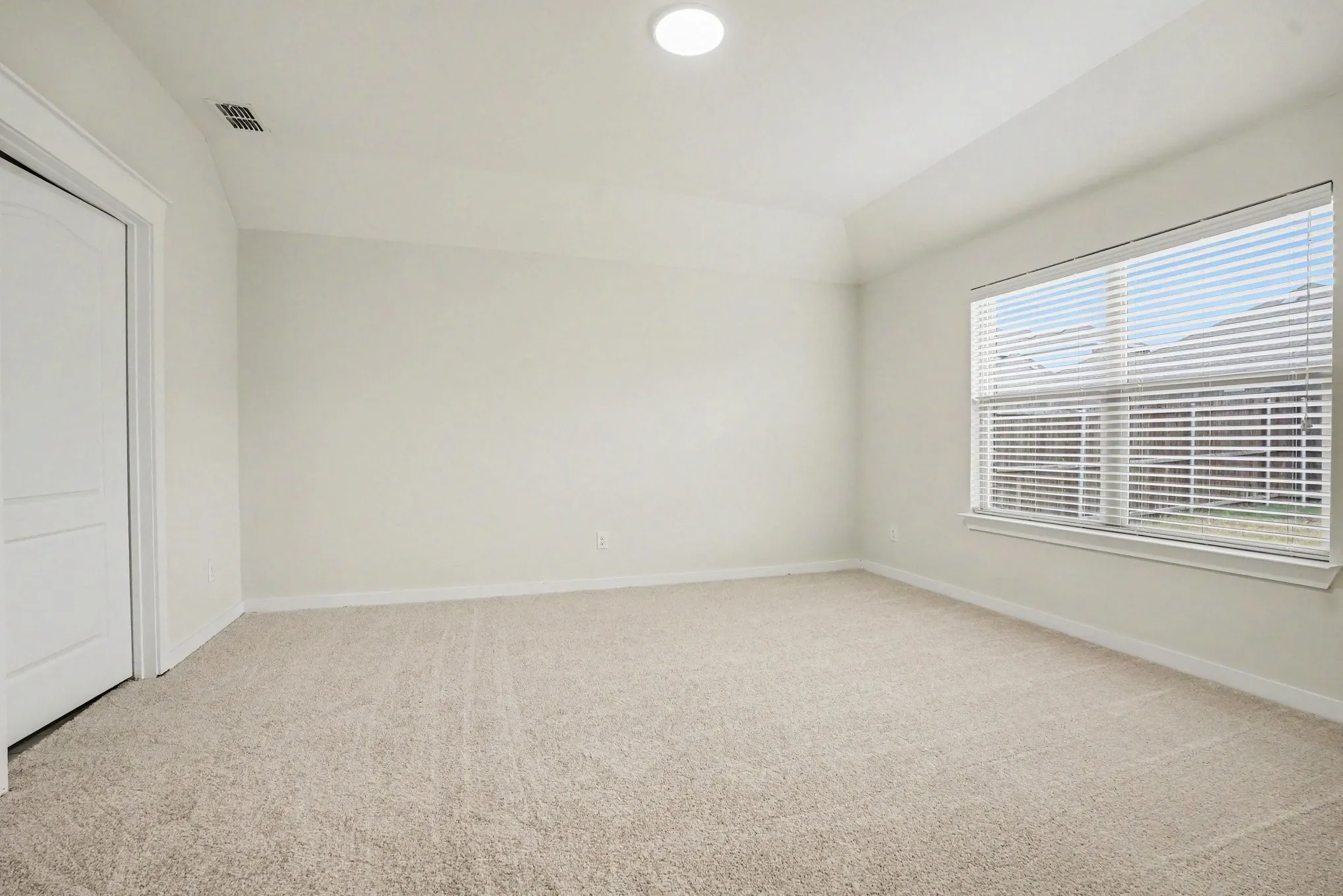 Master- Recessed lighting, neutral wall paint, light-colored carpeting, a window with blinds, and a white interior door
