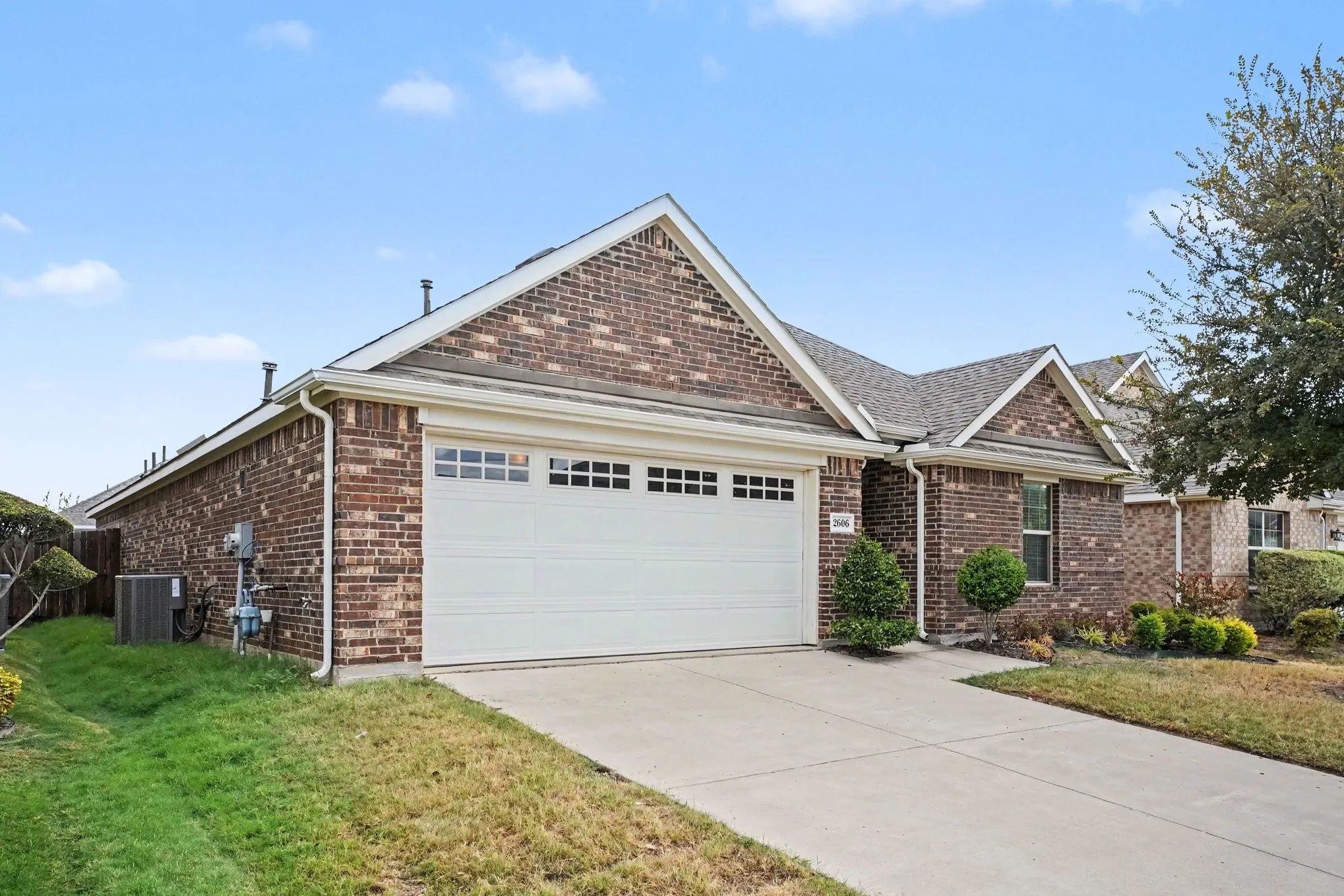 Brick exterior with a gabled roof and white garage door