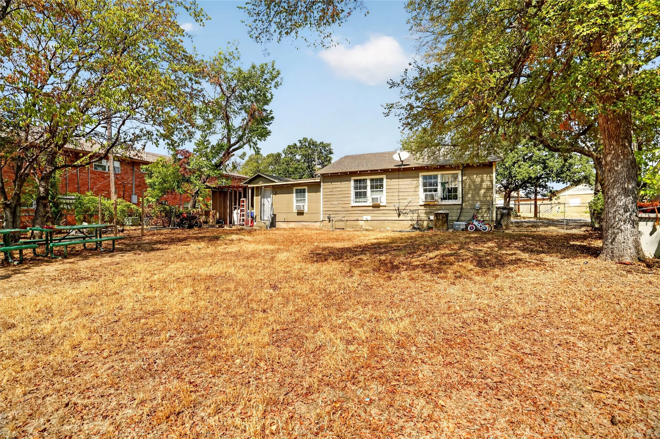 Rear exterior with multiple windows and mature trees