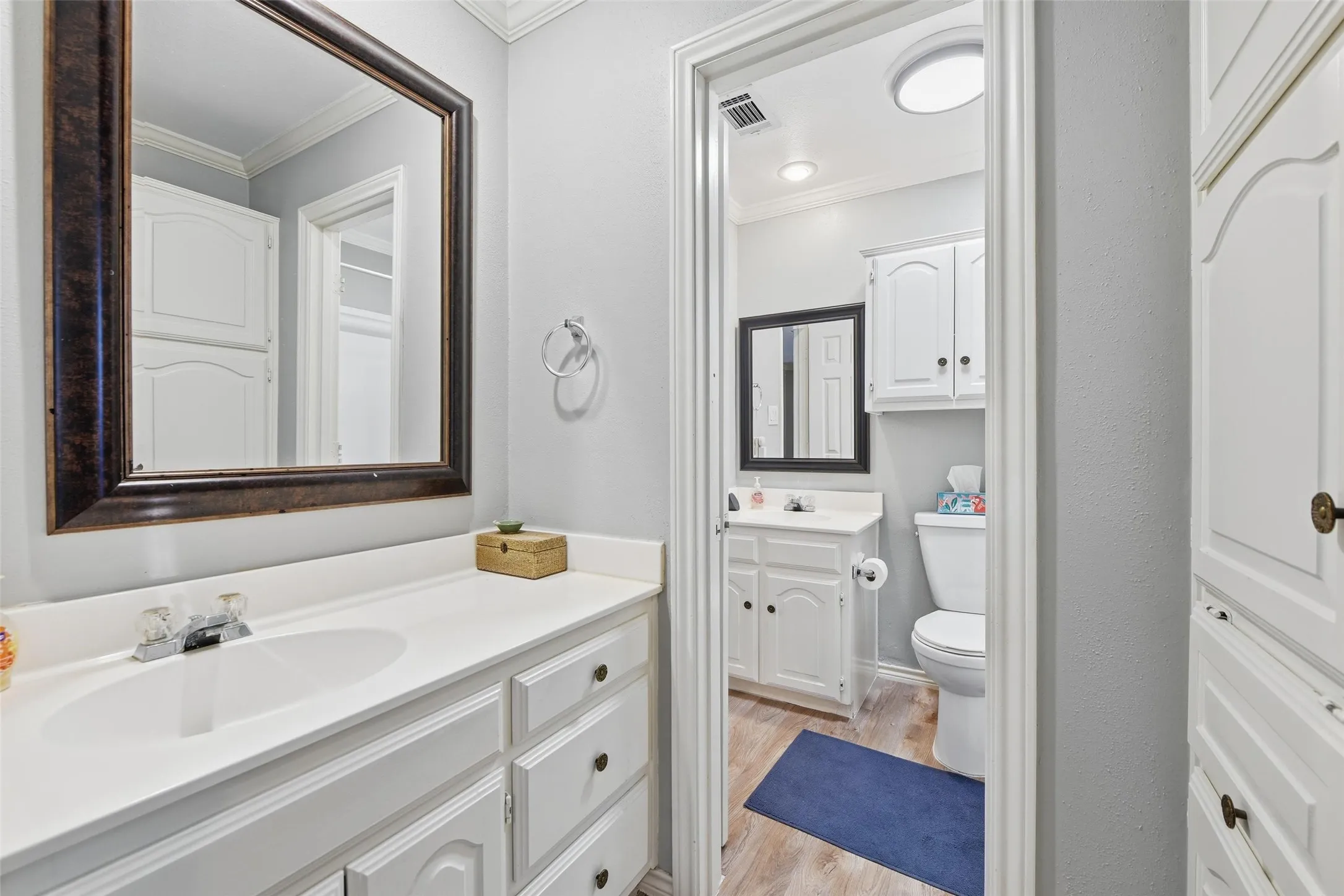 White vanity with an integrated sink, framed mirror, and chrome faucet