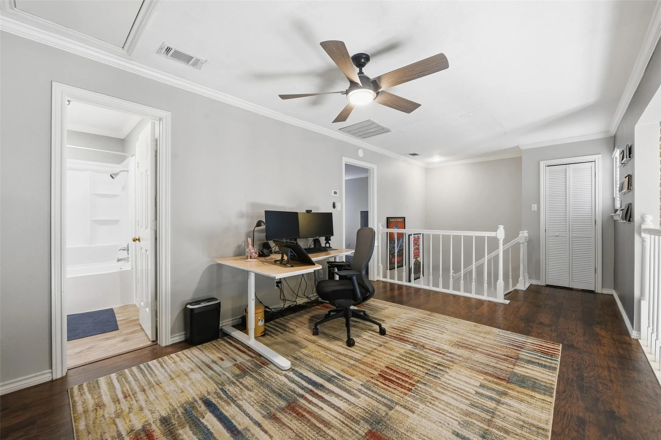 Hardwood-finish flooring, crown molding, ceiling fan with integrated lighting, and a full bathroom with a white tub and shower combination