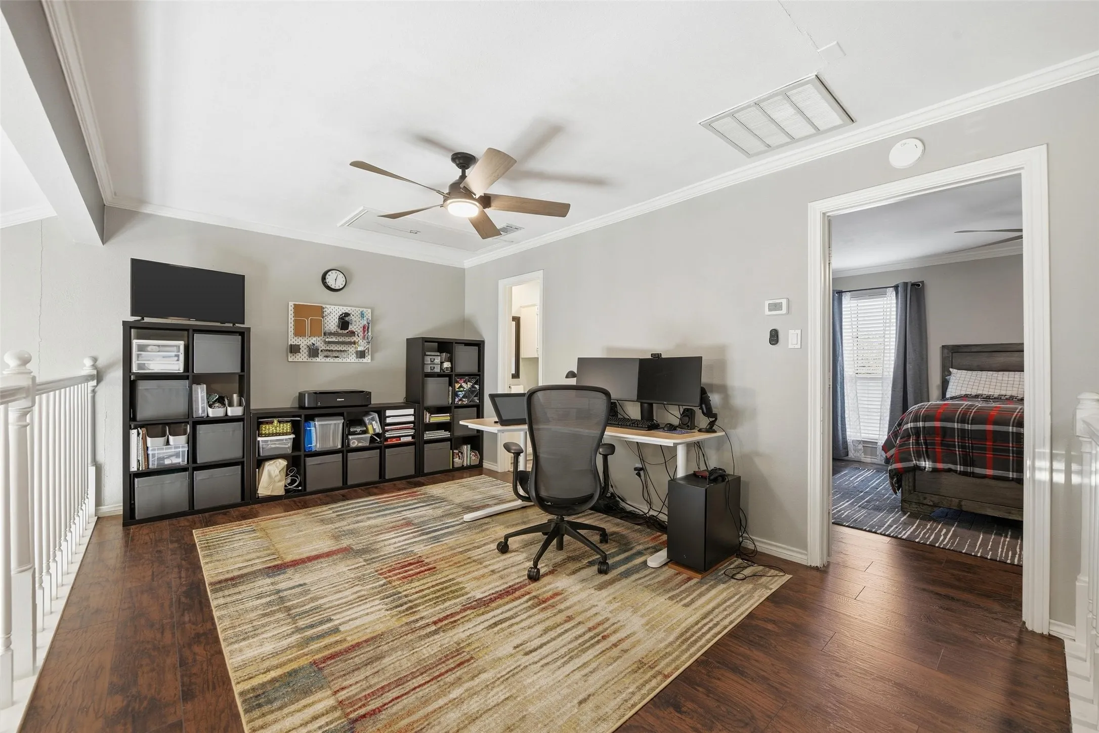 Wood-finish flooring throughout, complemented by light gray wall paint and white crown molding
