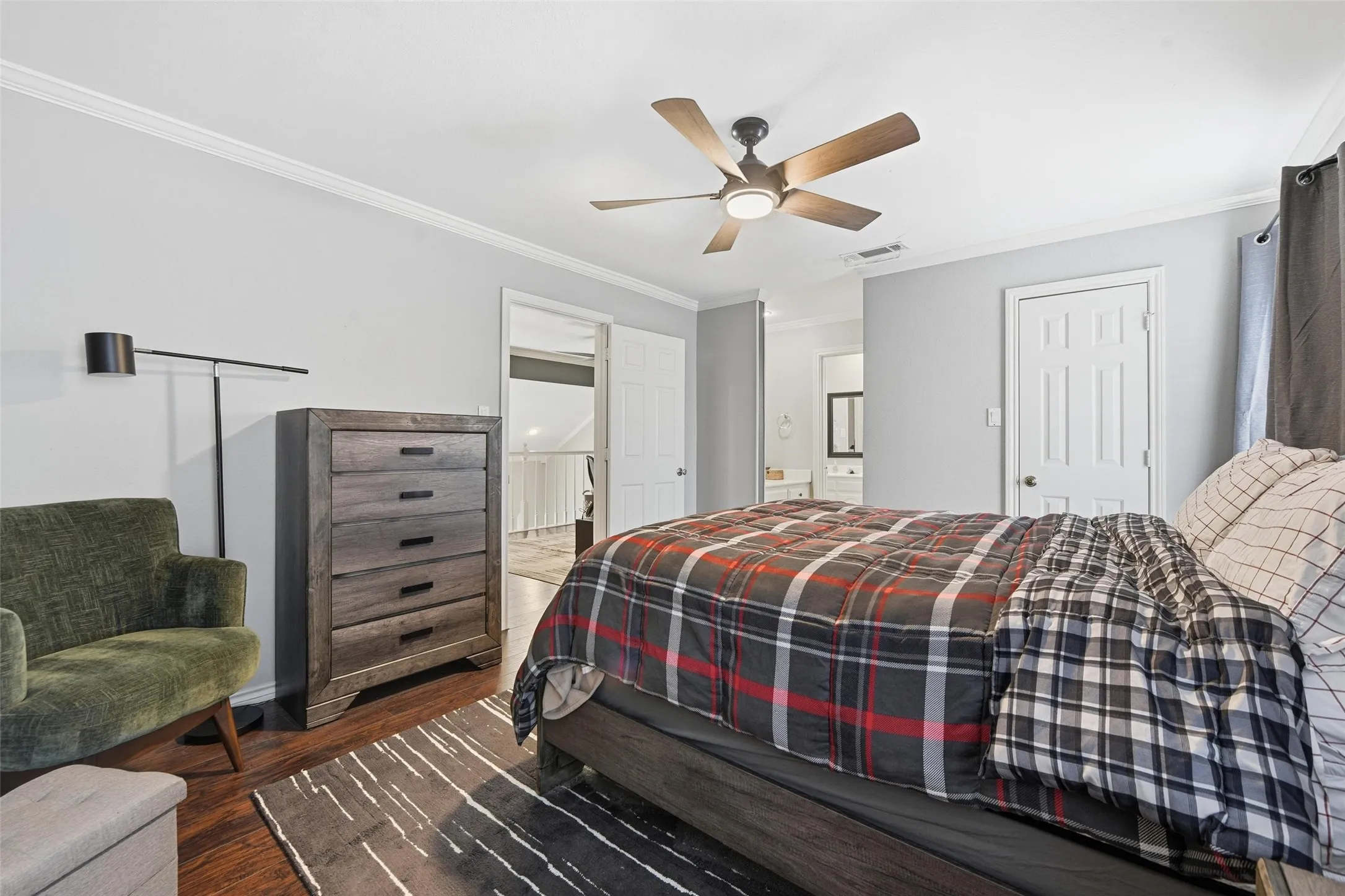 Wood-finish flooring, crown molding, and a ceiling fan with integrated lighting