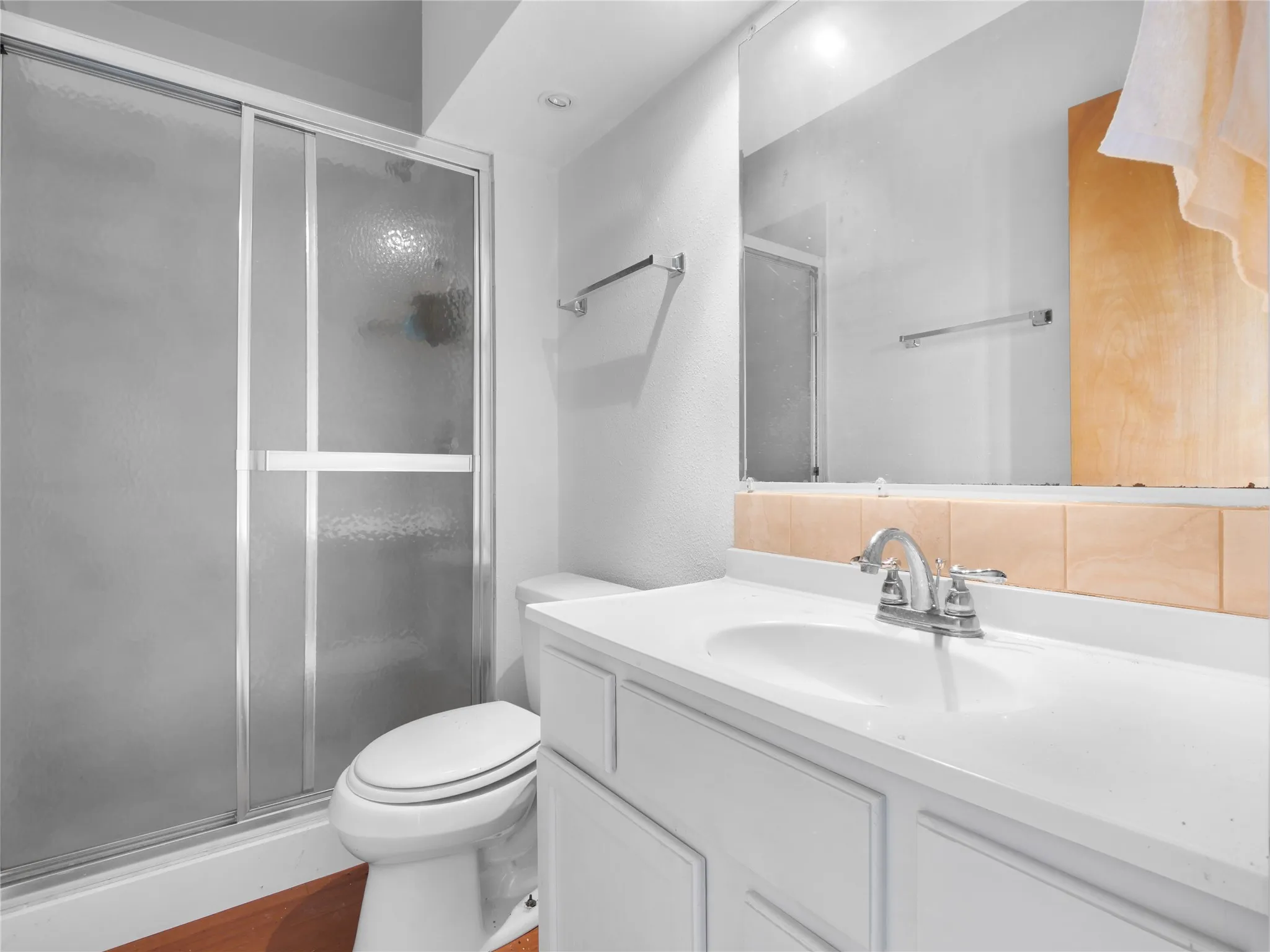 White vanity with integrated sink, chrome faucet, and full-width mirror