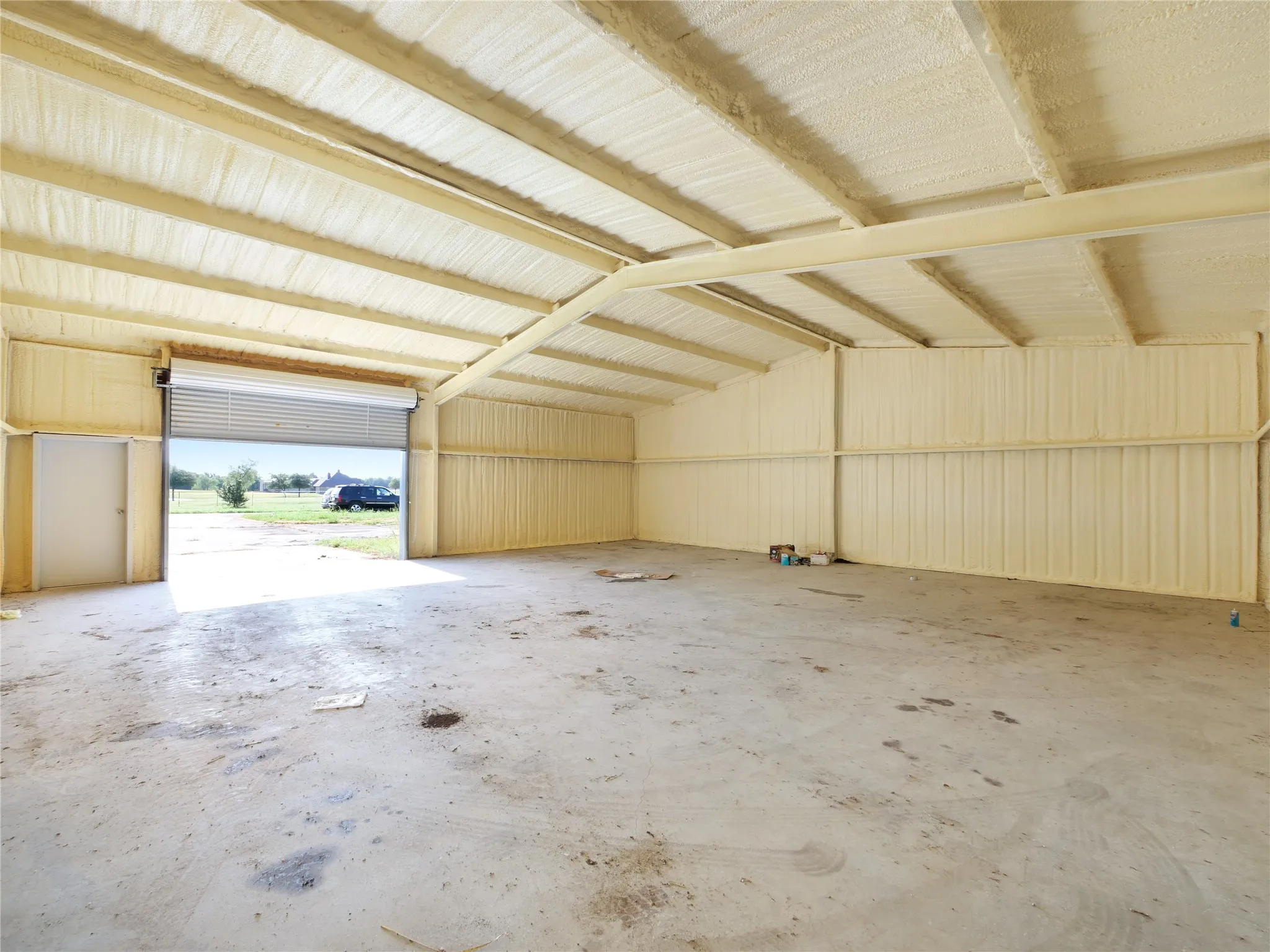 Spacious interior with concrete flooring and exposed metal beams