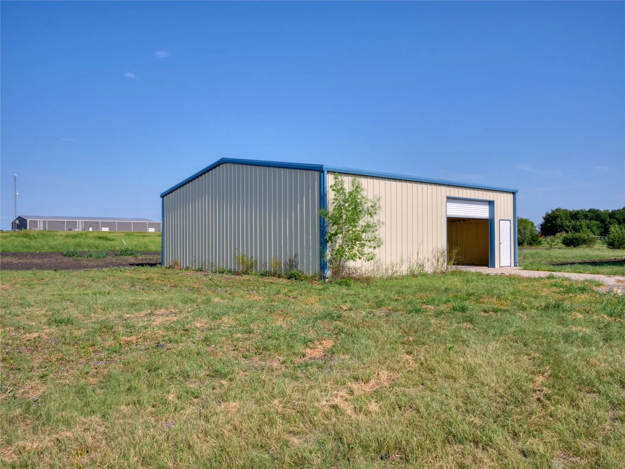 Metal building featuring a roll-up garage door and an entry door