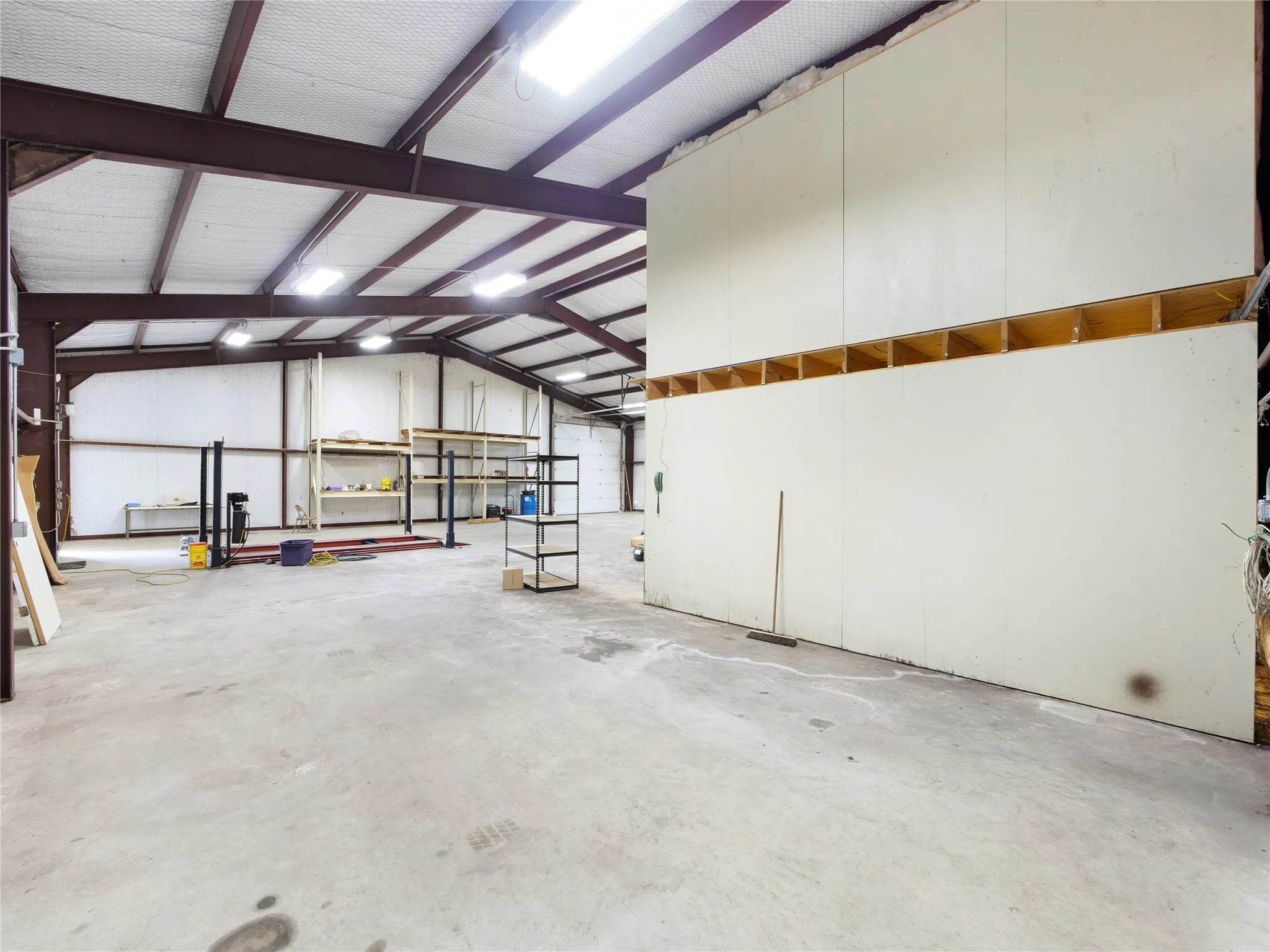 Expansive commercial interior with concrete flooring and exposed beam ceiling structure